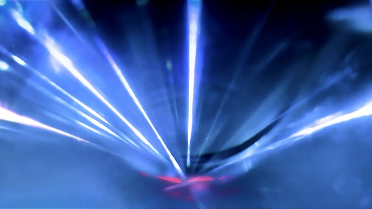 Bright blue and white laser lights radiating outwards in a futuristic pattern.