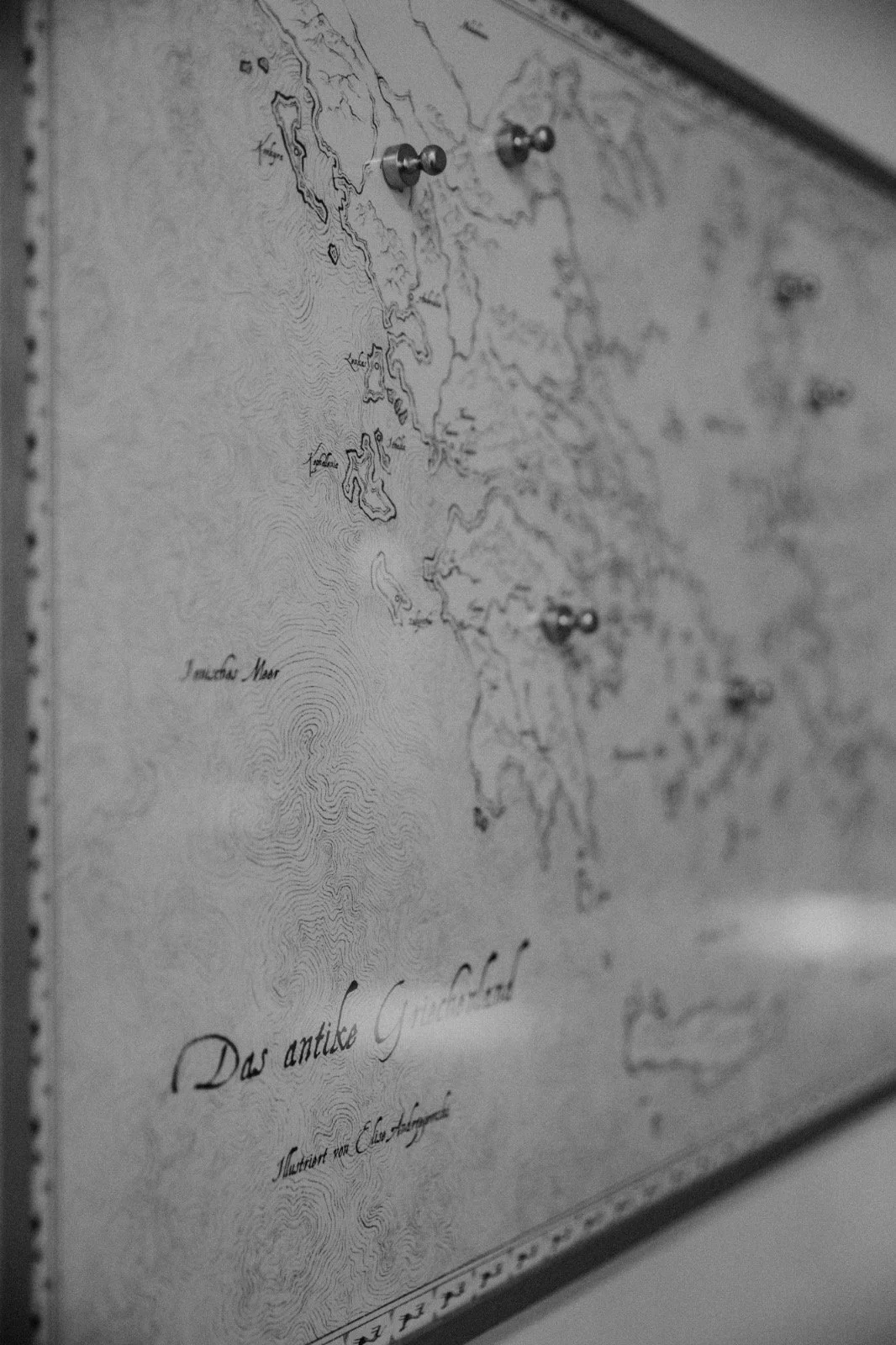 A black-and-white map of the coast of Iceland with labeled islands and water depths, pinned with metal push pins.