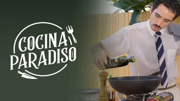 Un hombre cocinando en una sartén en una cocina moderna con letrero que dice 'Cocina paraíso'