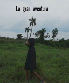 Cartel del cortometraje 'La gran aventura'. Un senderista en un campo verde con palmeras, mirando hacia arriba, con el título en la parte superior.