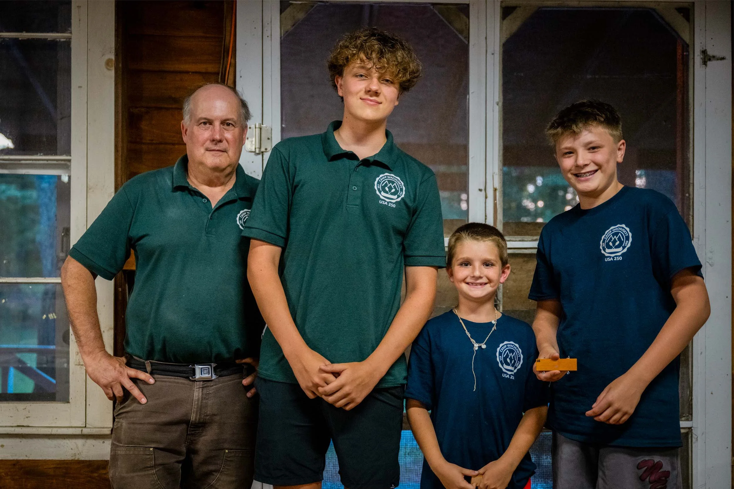Director Phil standing with a counselor and two campers.