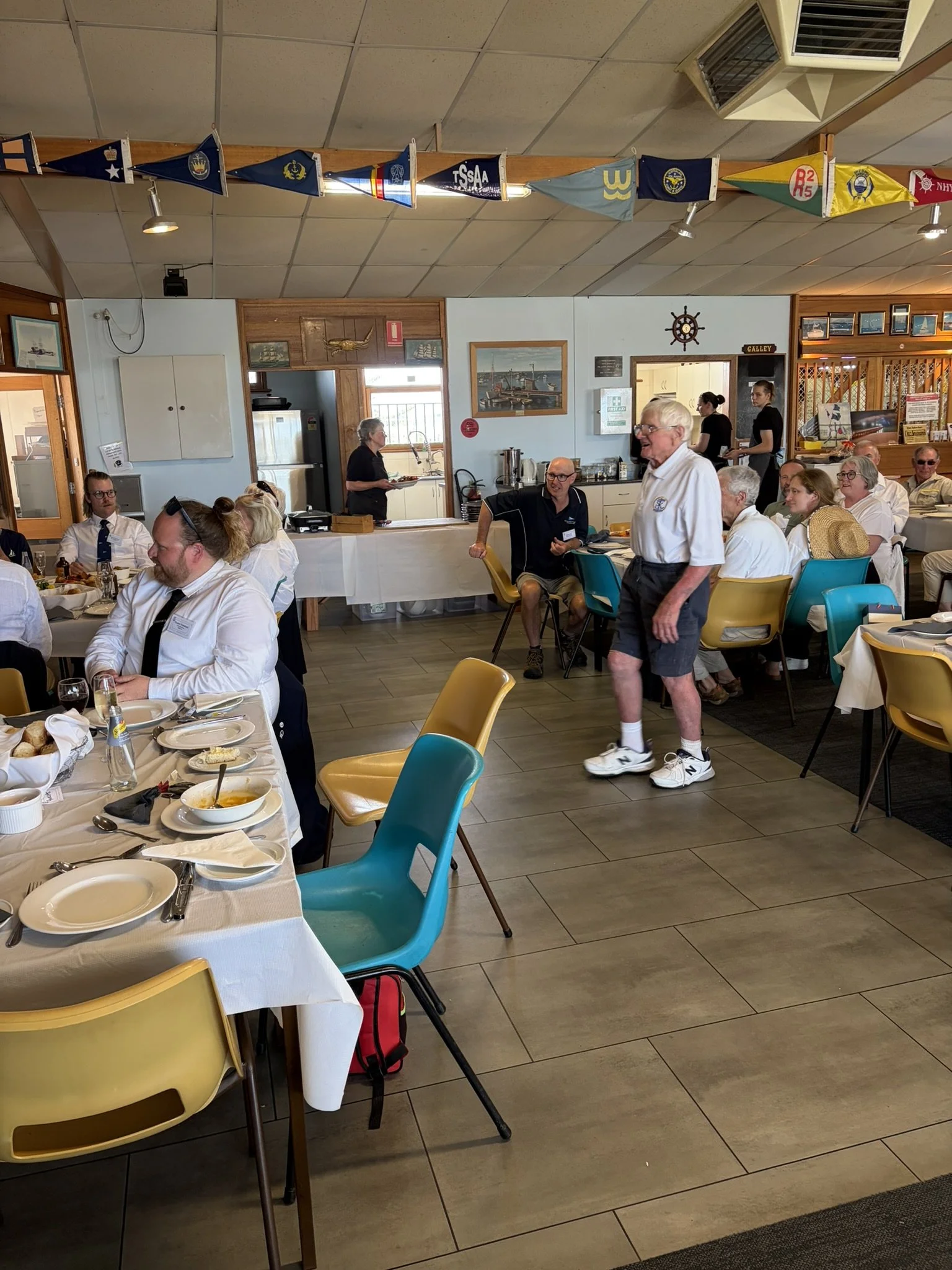SKBC life member, Mr Ray Brown, makes his way to the stage to receive his award for the "Best Traditional Sail Boat" in the 2026 sail past event.