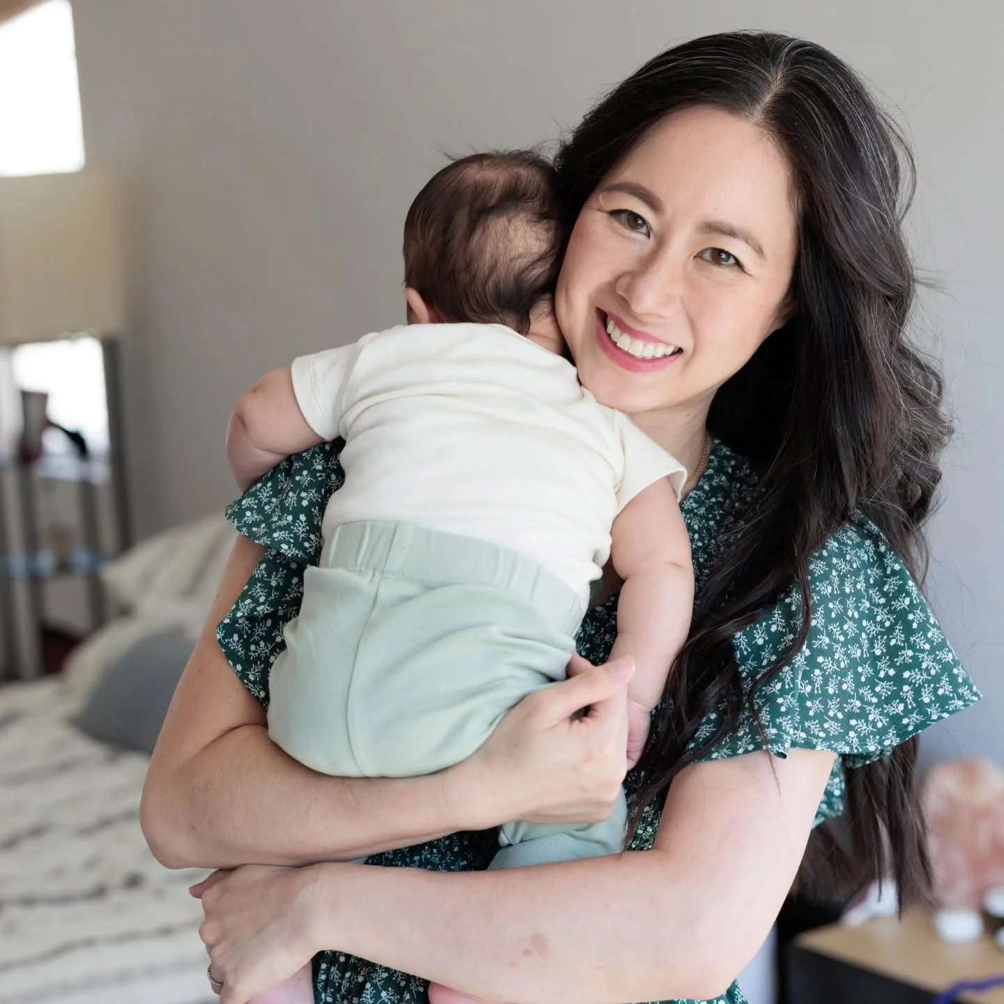 Smiling mother holding a baby at home