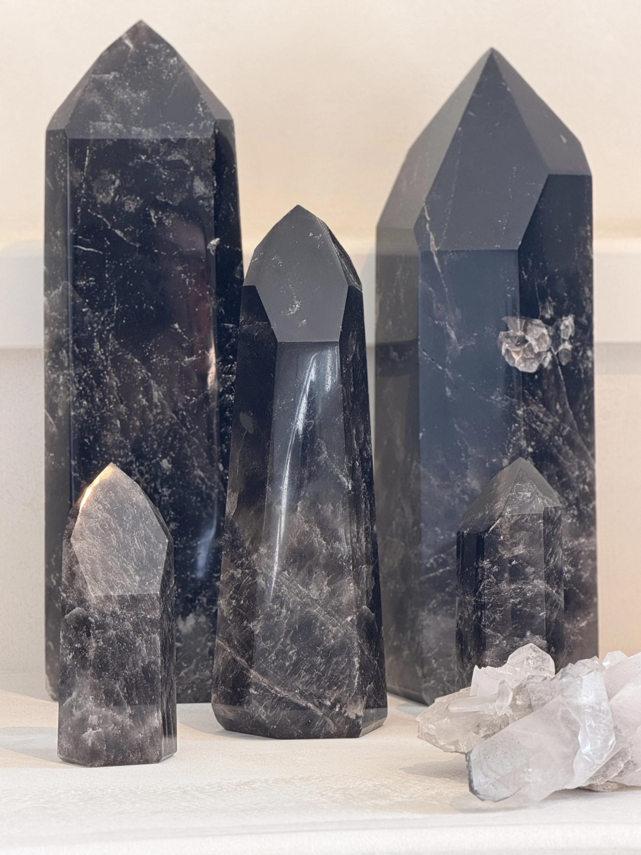 Several black and white crystals with pointed tips, set against a plain background.