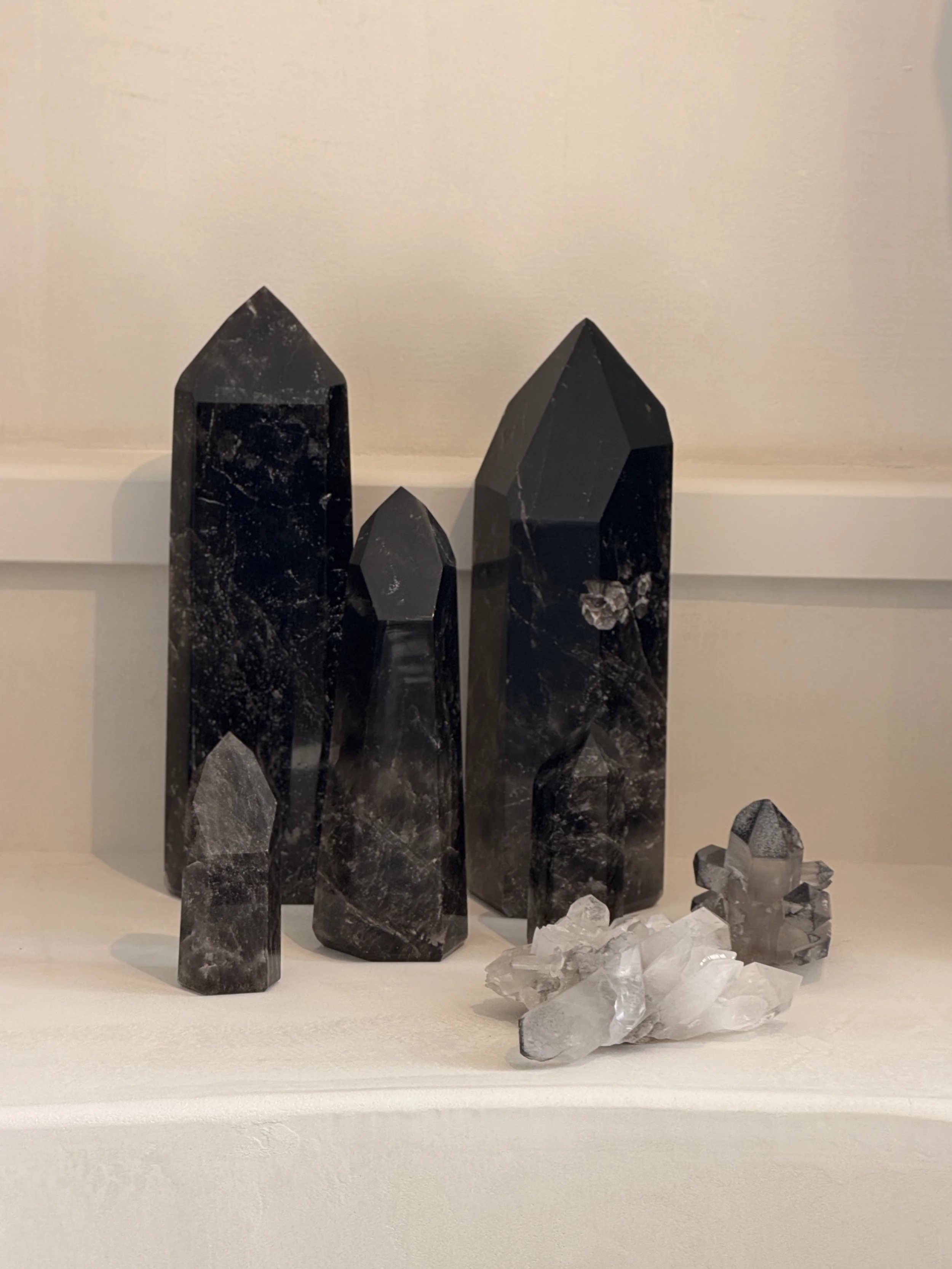 Collection of black marble crystals and white quartz crystals arranged on a white surface.