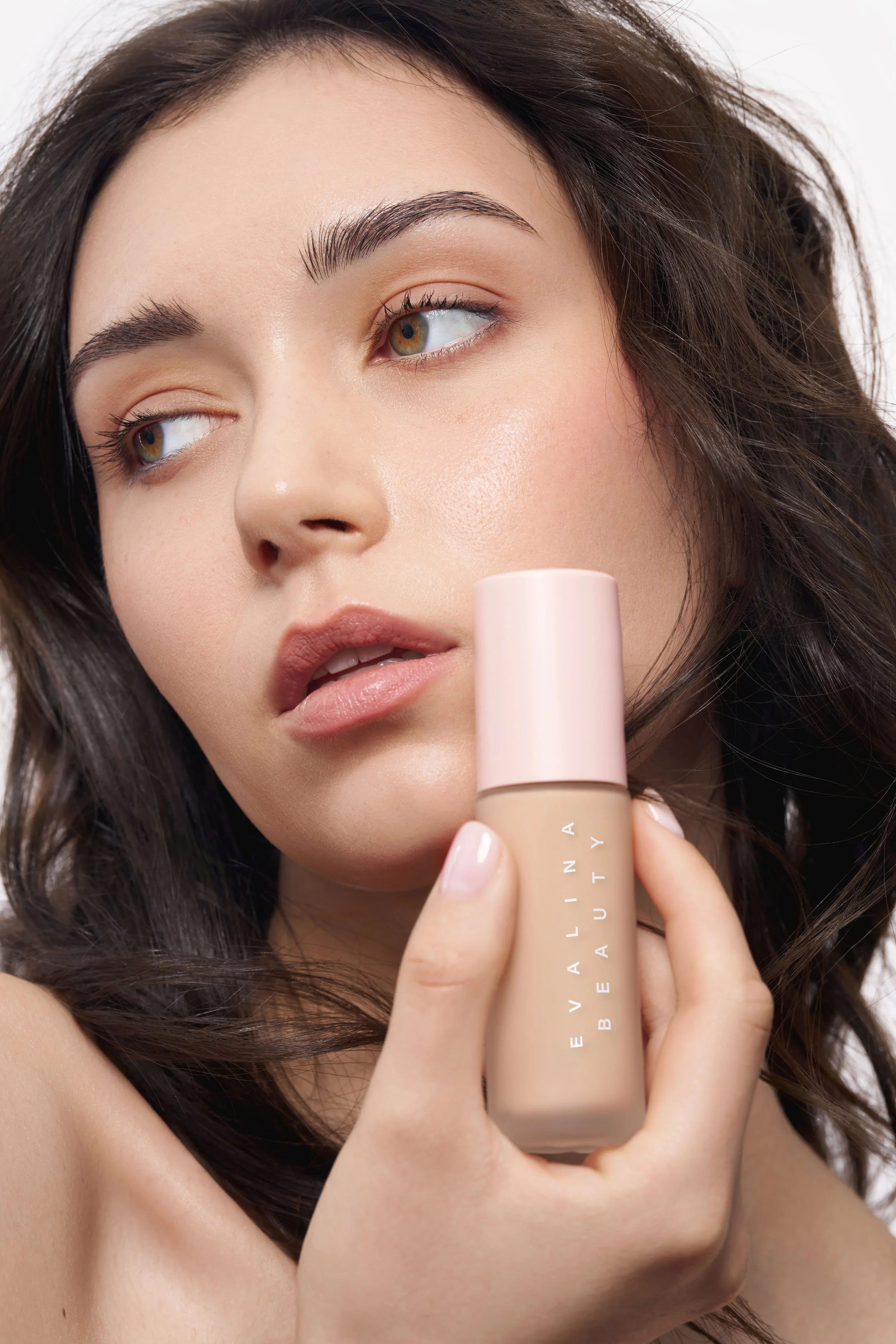 Beauty model holding foundation in a cosmetics campaign – Noirvellel
