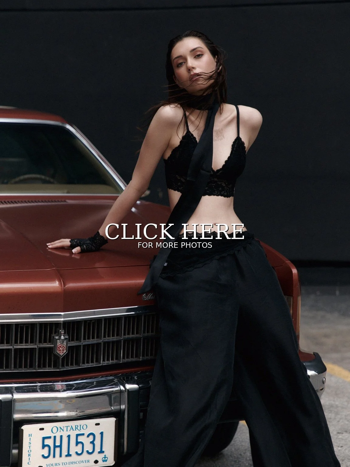 Noirvellel posing beside a vintage car in a dark fashion editorial.