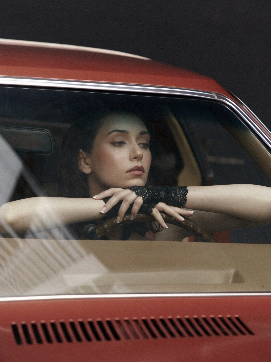 Fashion model posing inside a vintage car for a cinematic editorial – Noirvellel
