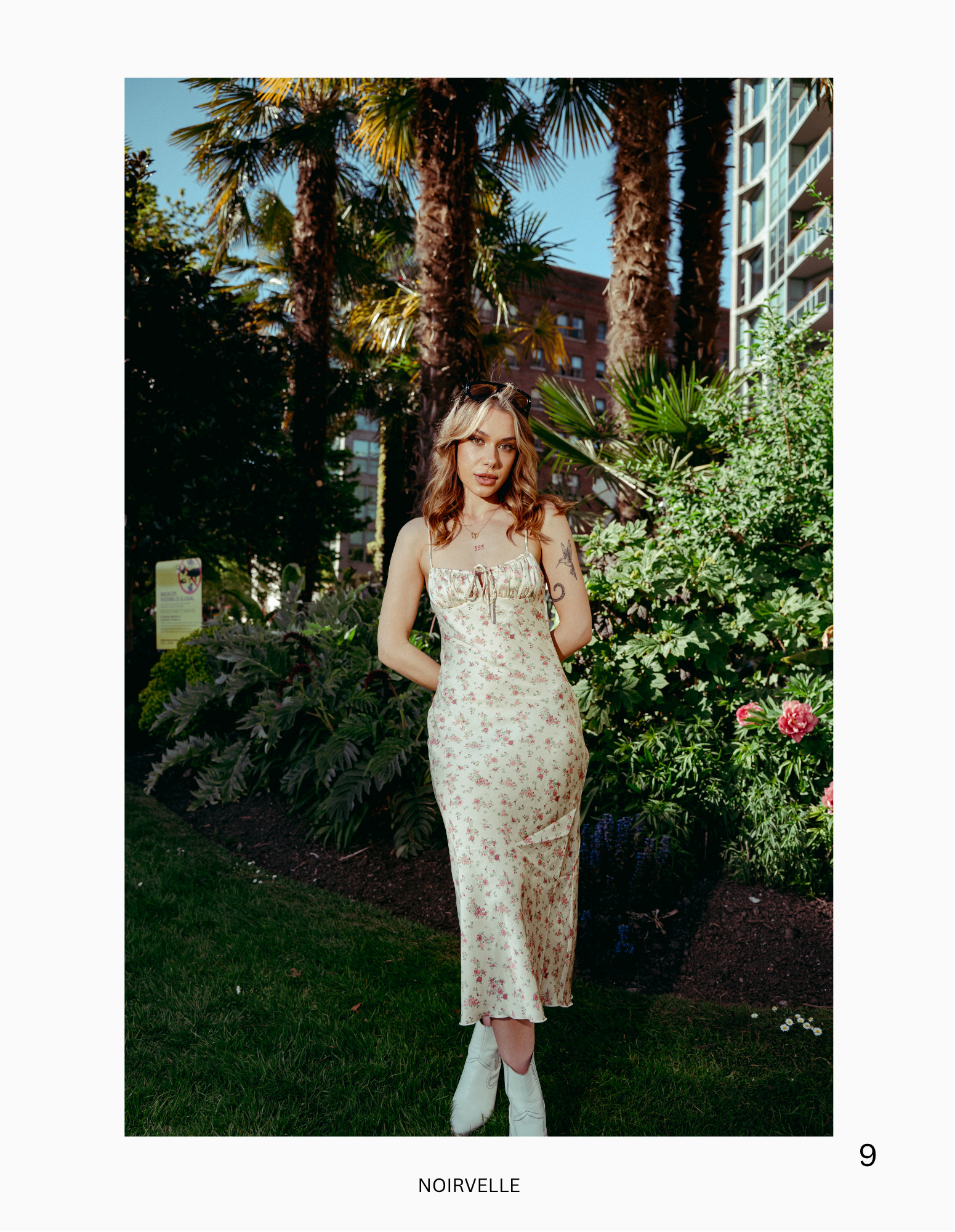Outdoor fashion portrait featuring a female model in floral styling, photographed in an urban garden setting.

