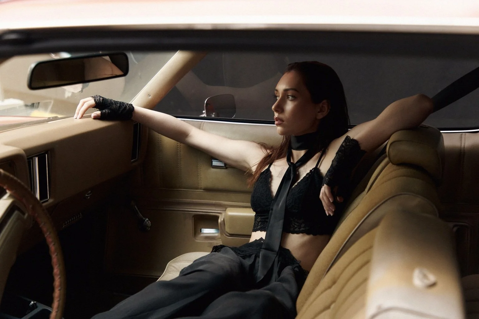 Professional fashion model in a luxury vintage car editorial – Noirvellel
stretched out along the headrests.