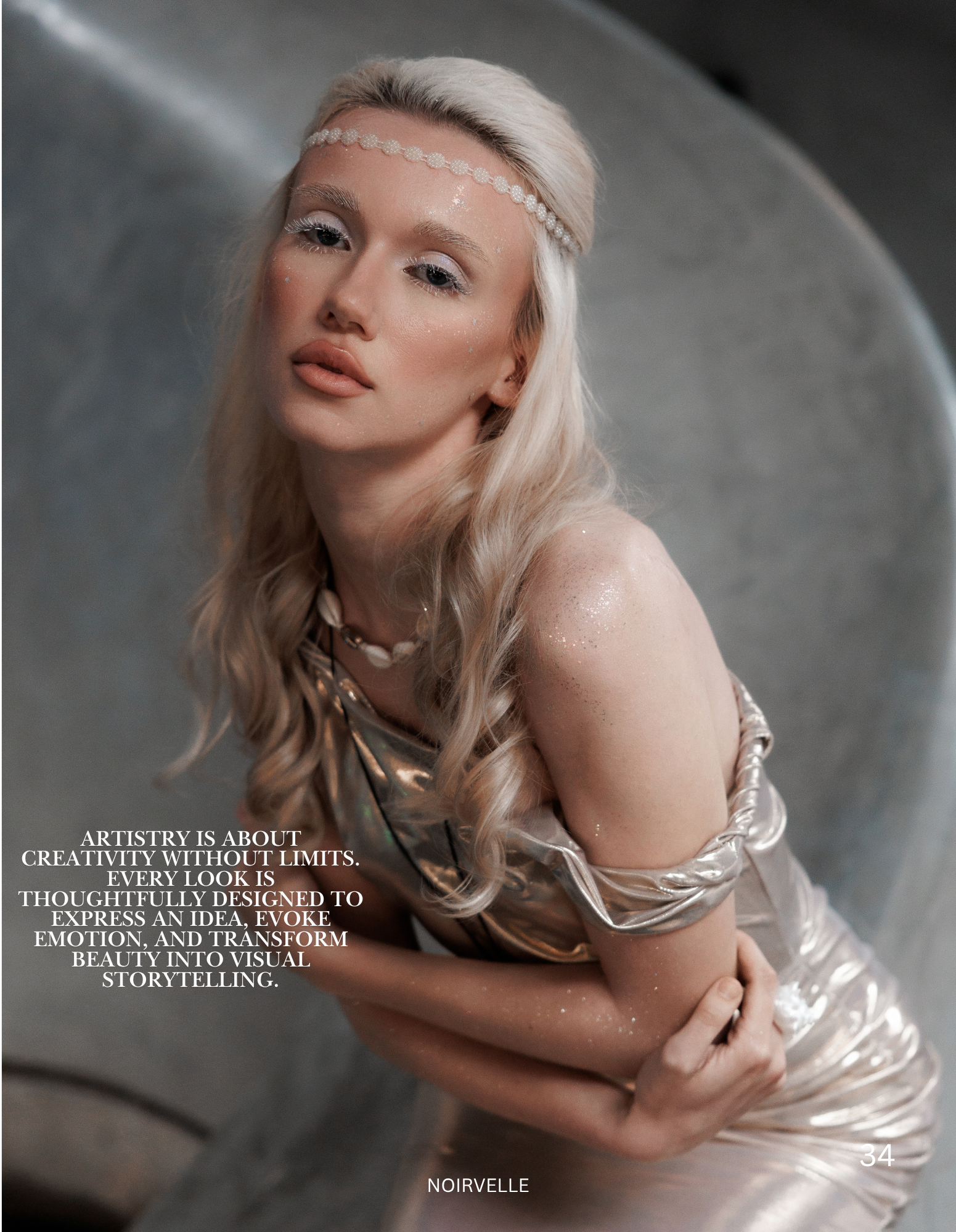 A close-up of a woman with platinum blonde hair styled in loose waves, adorned with a pearl headband, and makeup featuring white eyelashes, glitter on her face, and a natural lip color. She is wearing a shiny, light-colored satin dress with ruffled s