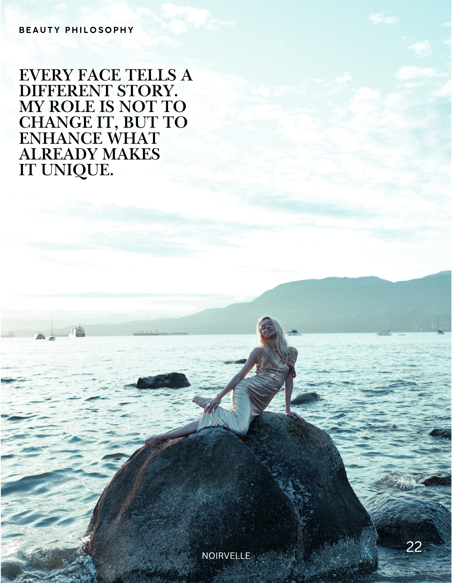 A young woman with long blonde hair, wearing a silky dress, sits on a large rock in the water by the shore, with a calm sea and boats in the background, under a cloudy sky.