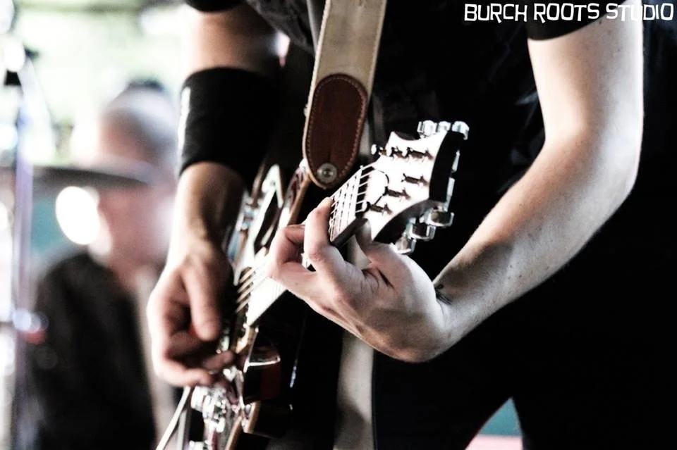 close picture of Kris playing a PRS guitar live on stage
