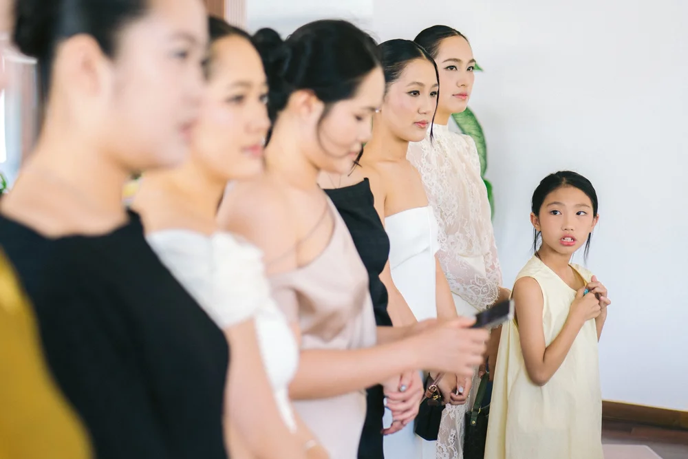 Women standing in a row with a young girl looking to the side