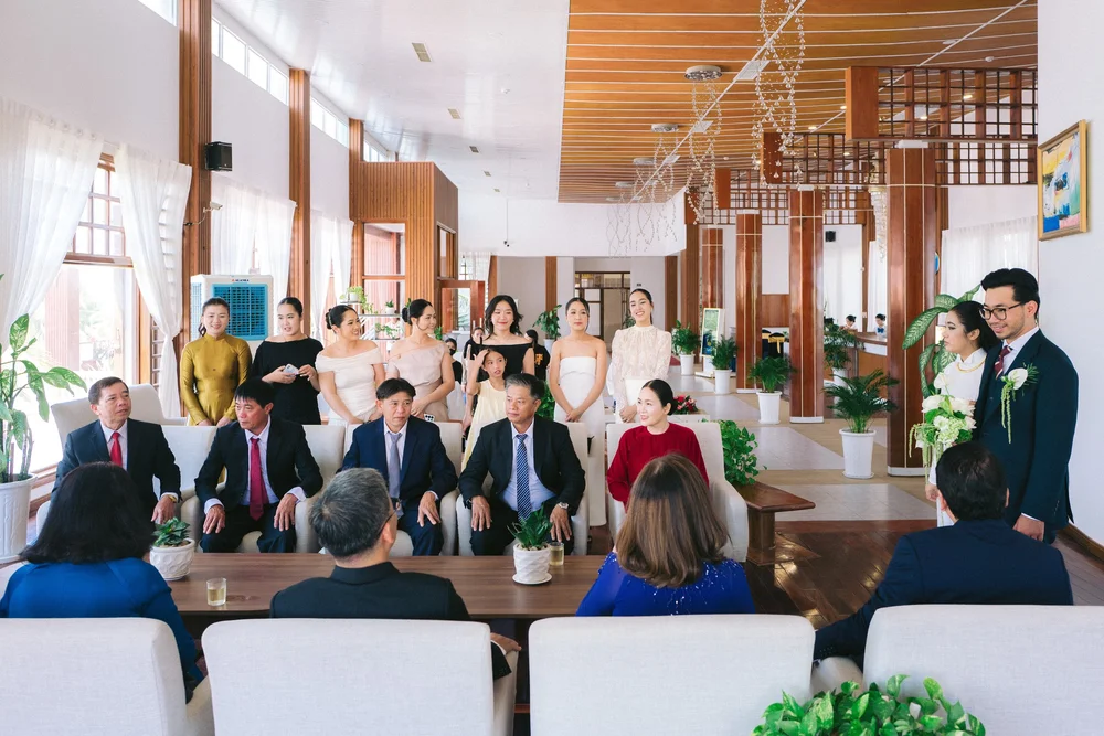 A wide view of people seated and standing together, with the couple at the right