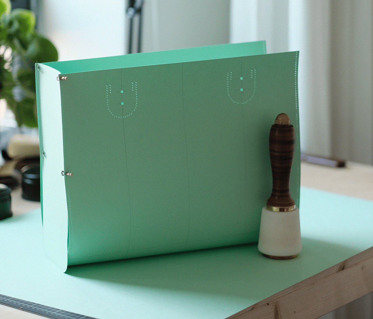 A green hockey shootout goal with a brown and white goalie training aid next to it on a desk.