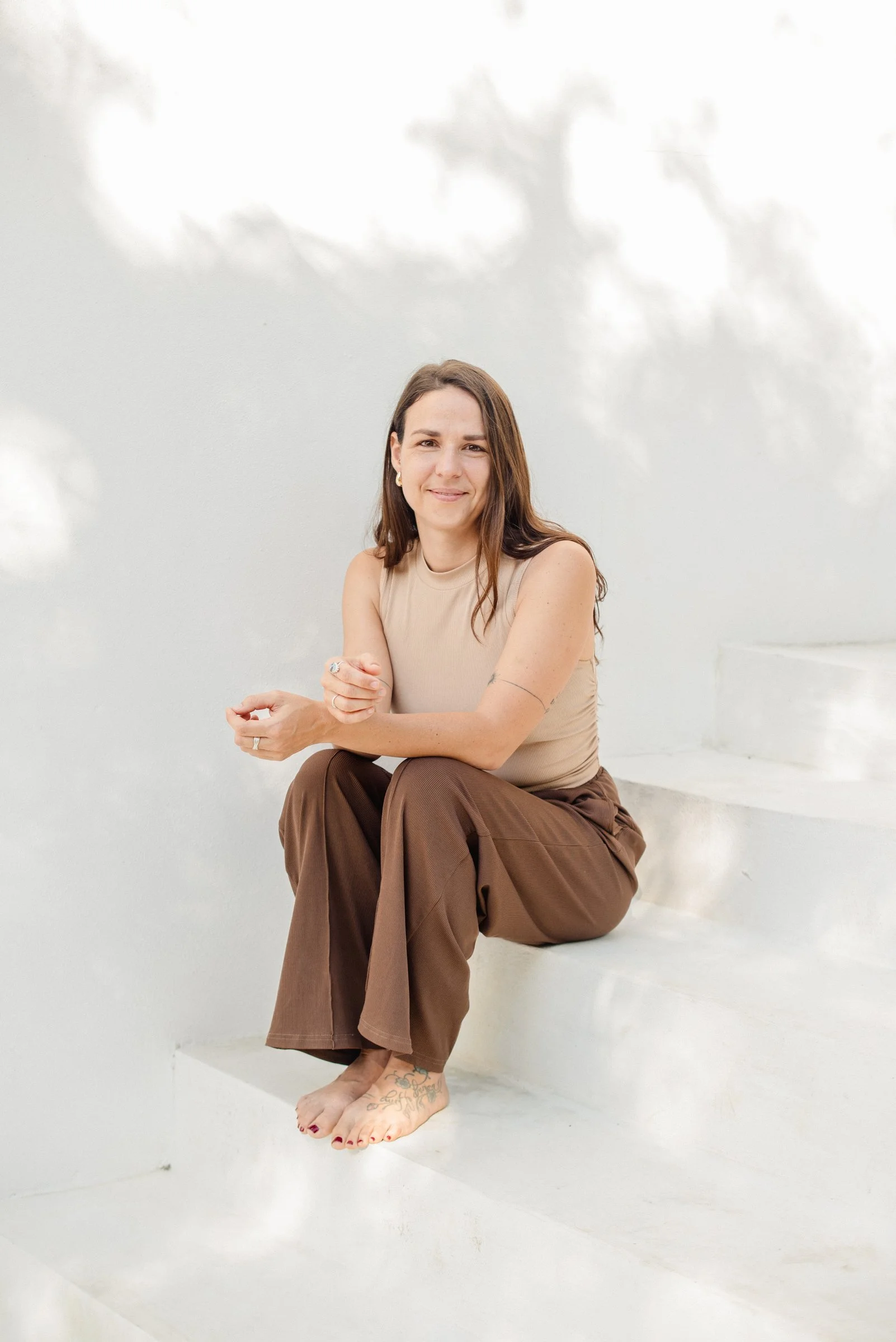 Larissa Van de Bilt, founder of Studio VDB, sitting on white steps