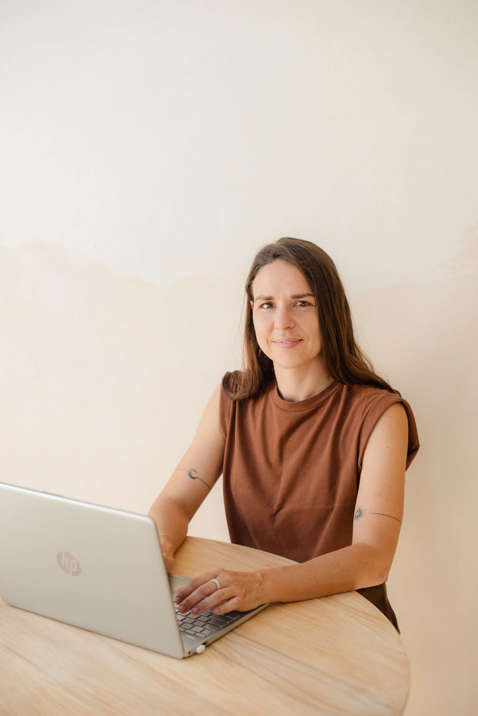 Larissa Van de Bilt working on a laptop at a wooden table