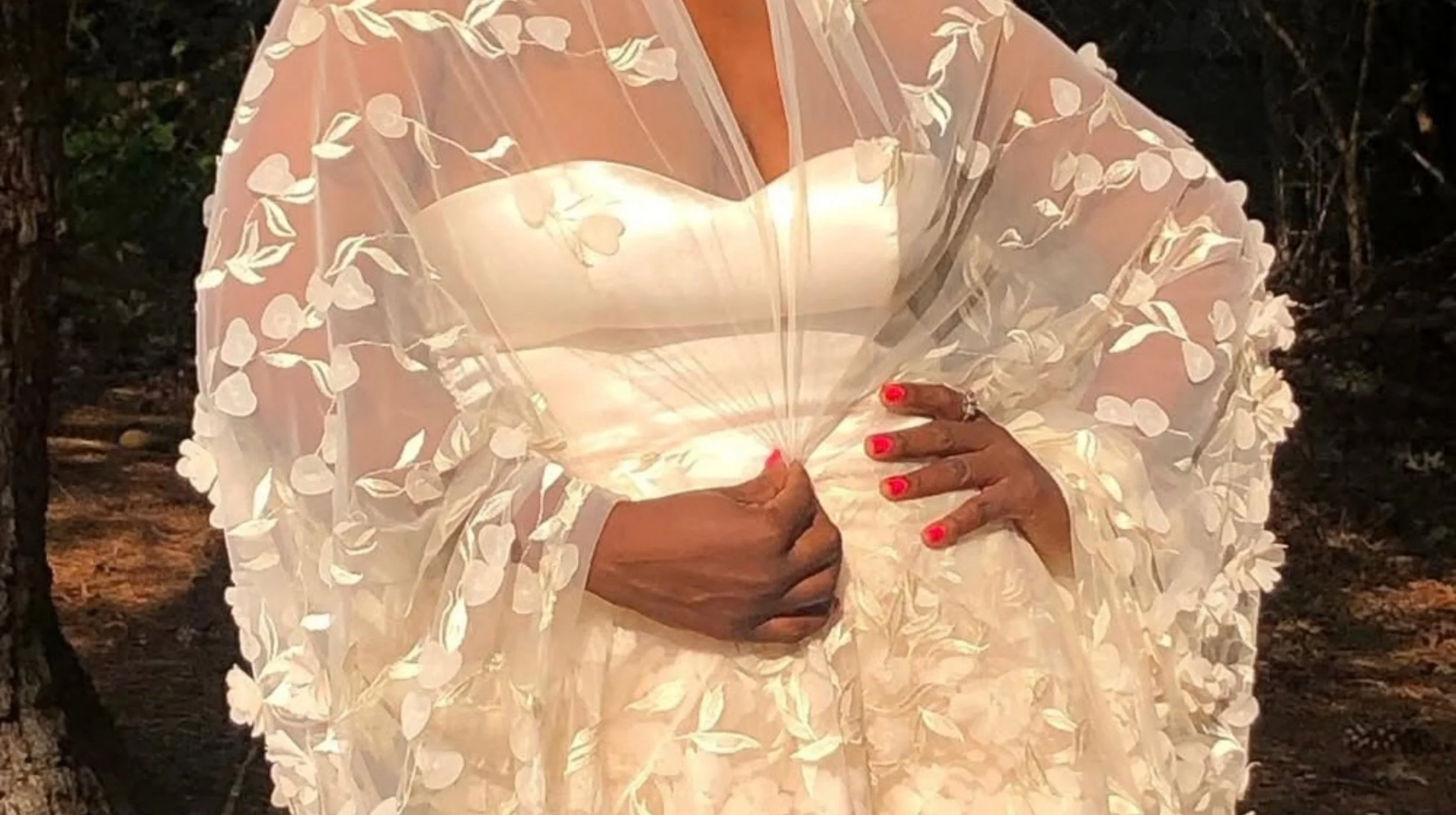 Close-up of an ivory Sheridonna Designs bespoke gown featuring a structured sweetheart corset and dimensional floral appliqué.