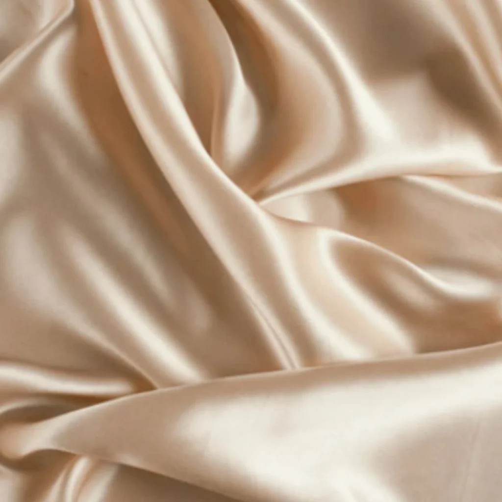 Ivory satin fabric draped in soft folds representing the beginning of the Sheridonna Designs bespoke process.
