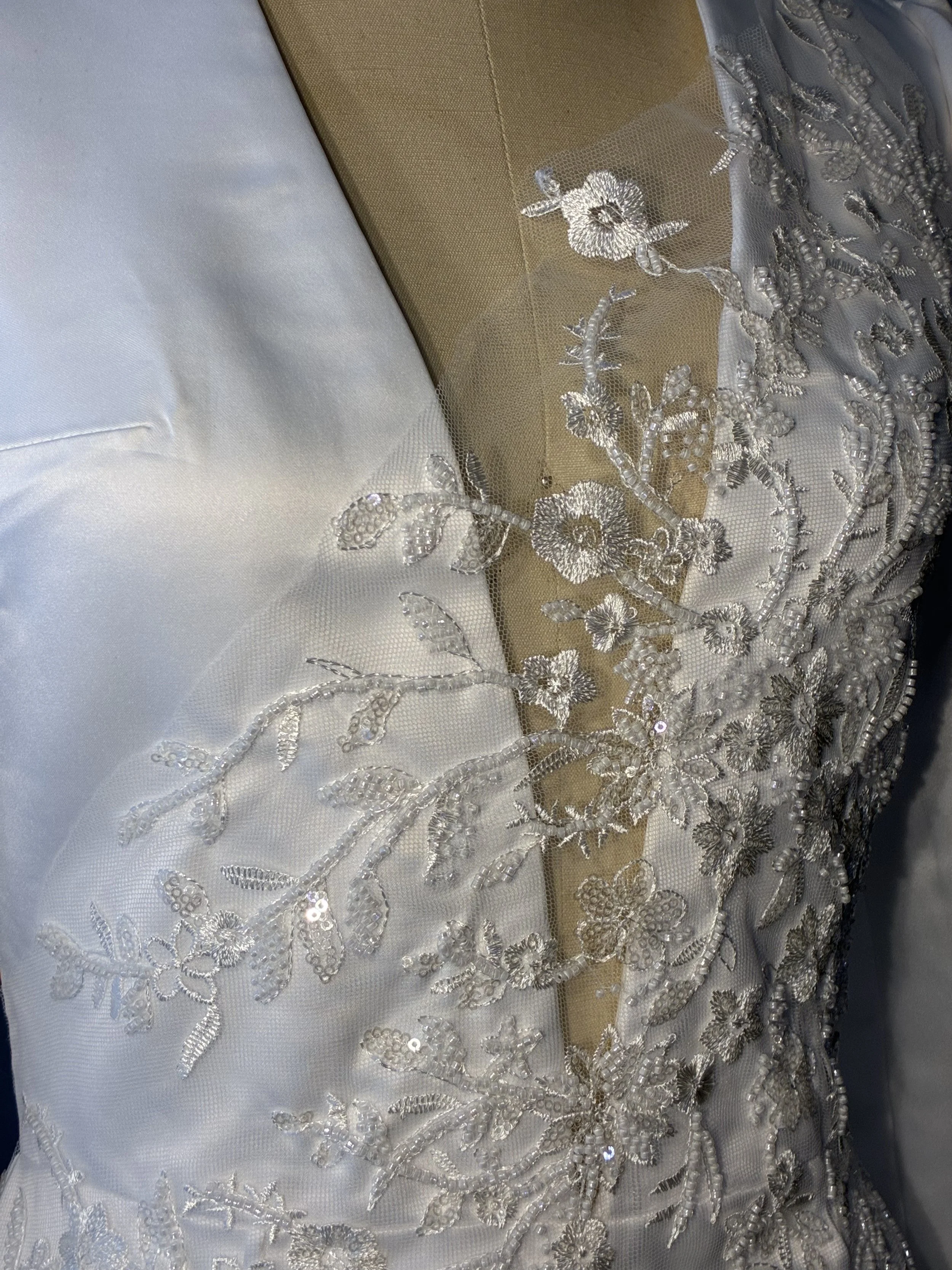 Detailed view of white beaded floral lace appliqué and satin used in a bespoke Sheridonna Designs garment.
