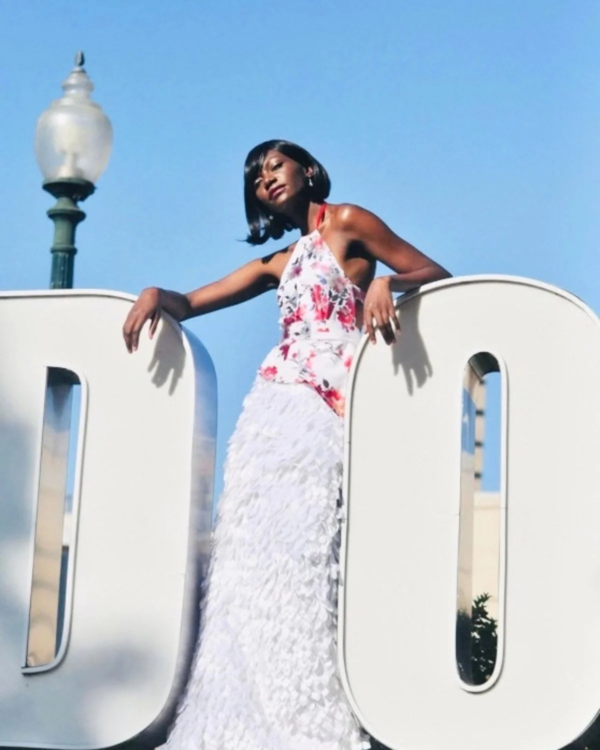 Model wearing a completed Sheridonna Designs bespoke floral halter gown with a white textured skirt.