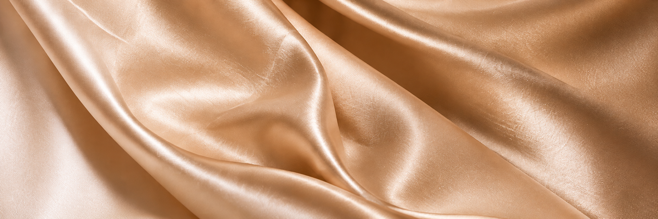 Champagne ivory satin arranged in flowing folds, representing the refined materials and craftsmanship of Sheridonna Designs.