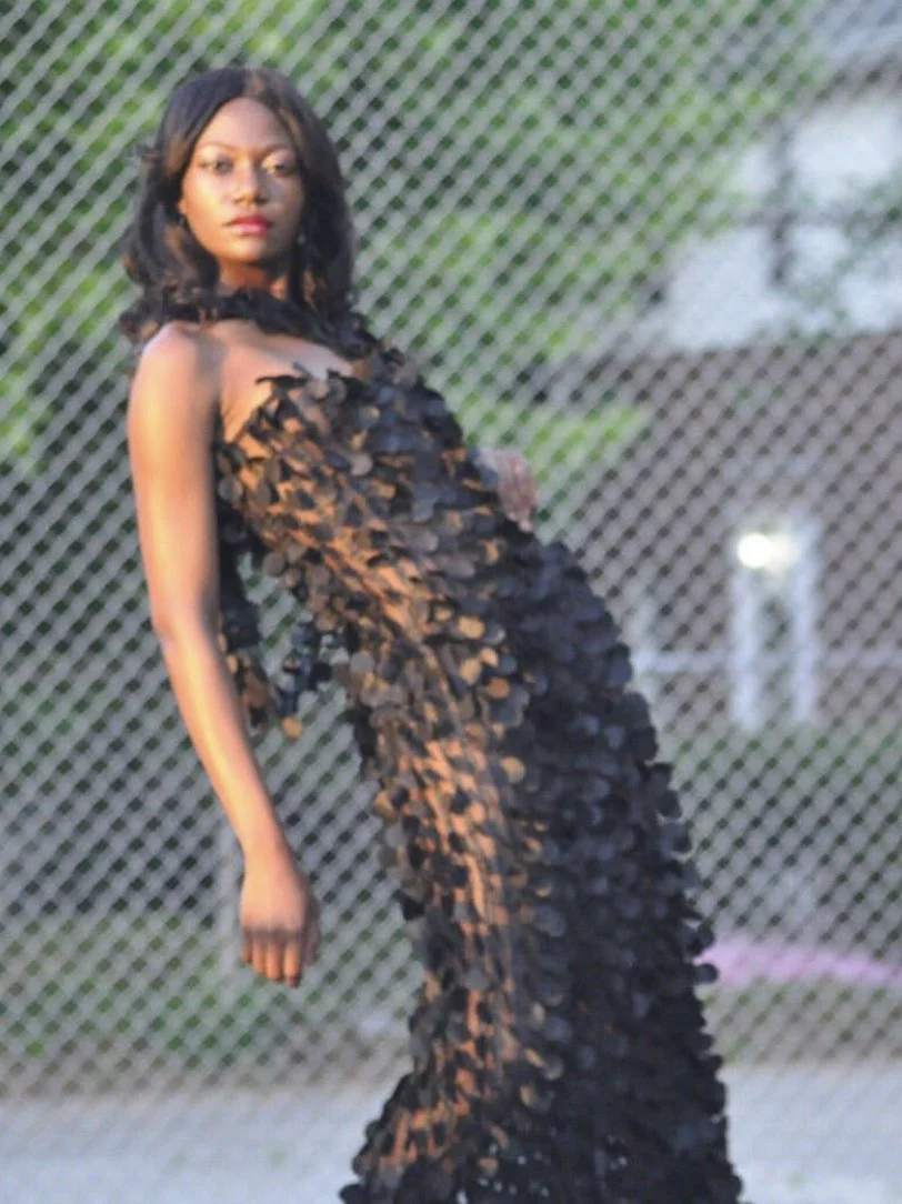Model wearing a dramatic black sculptural petal gown by Sheridonna Designs.