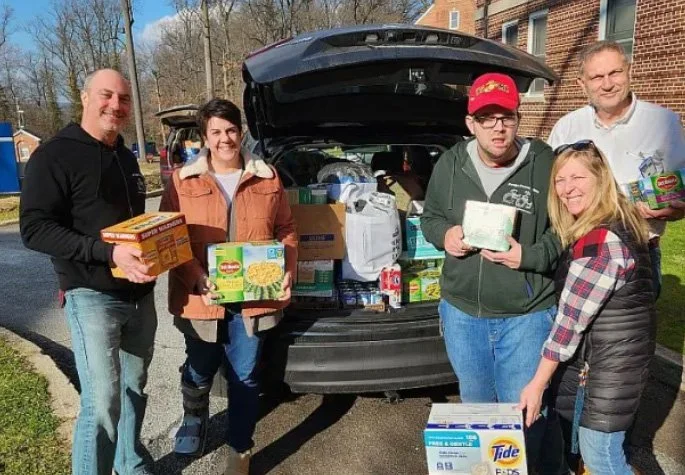 Anthony Cracchiolo, Jake Herring, and their team unpacks a car at the 2023 Coatesville VA Residential Hospital donation drive.