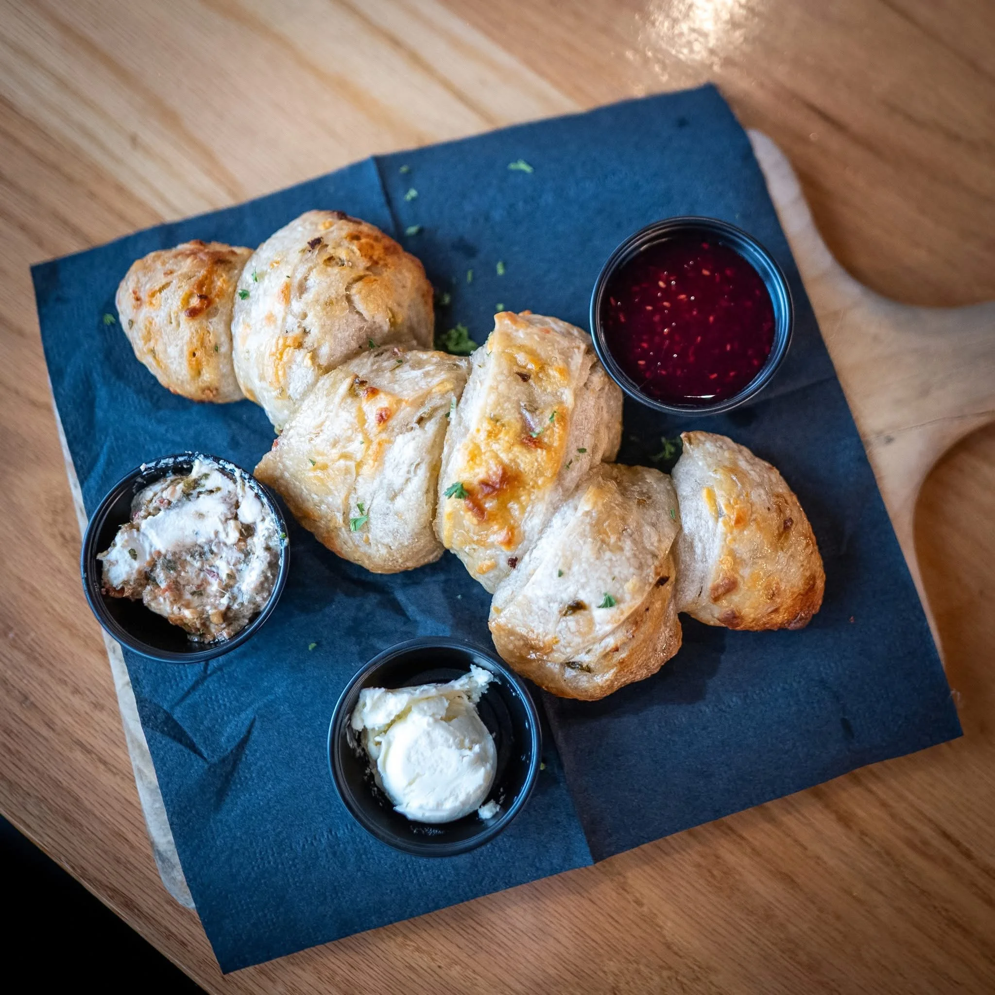 Sourdough bread served with small bowls of accompaniments on a blue serving board at Public House in Amarillo, Texas.