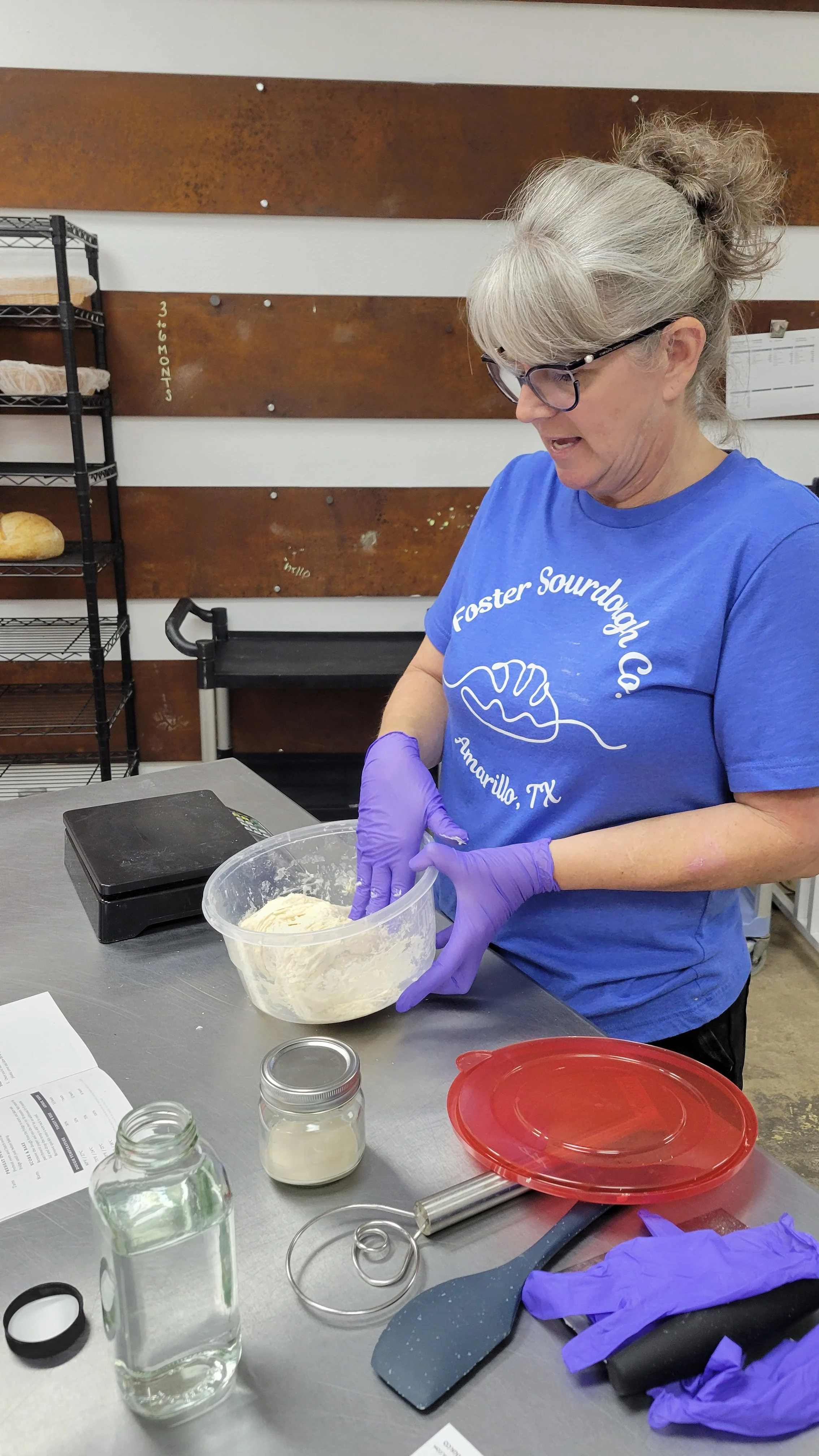 Chris Foster demonstrating dough preparation at a sourdough class workstation.