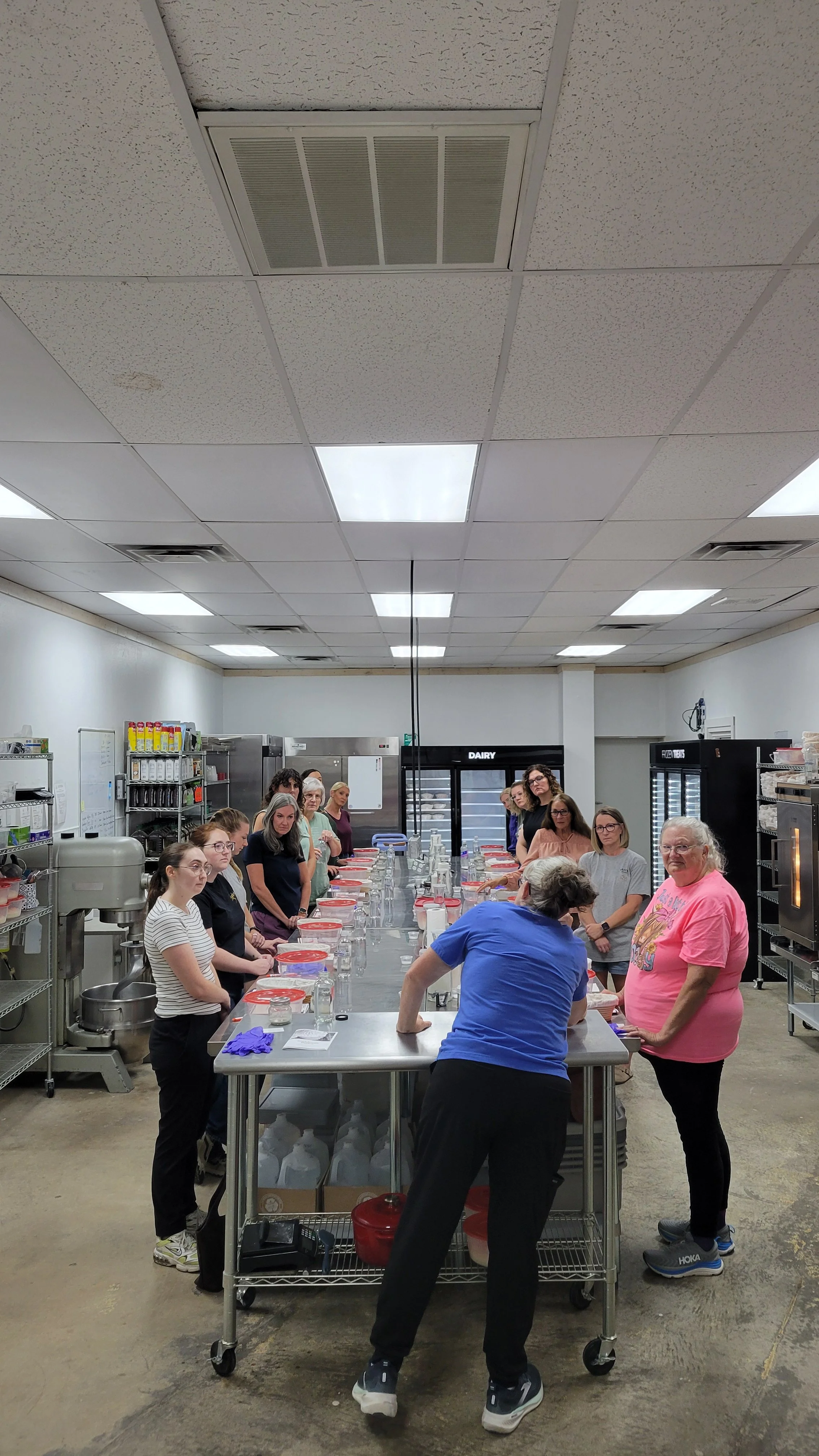 Sourdough class participants gathered around a worktable in the bakery kitchen.