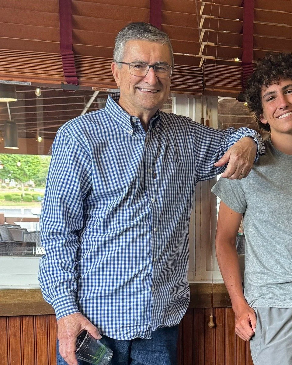 aJoe Besnard smiling in a blue checked shirt