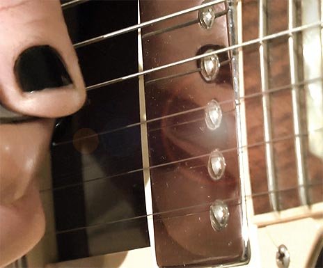 Gitarrenlehrer Karima spielt auf der E-Gitarre mit Plektrum.