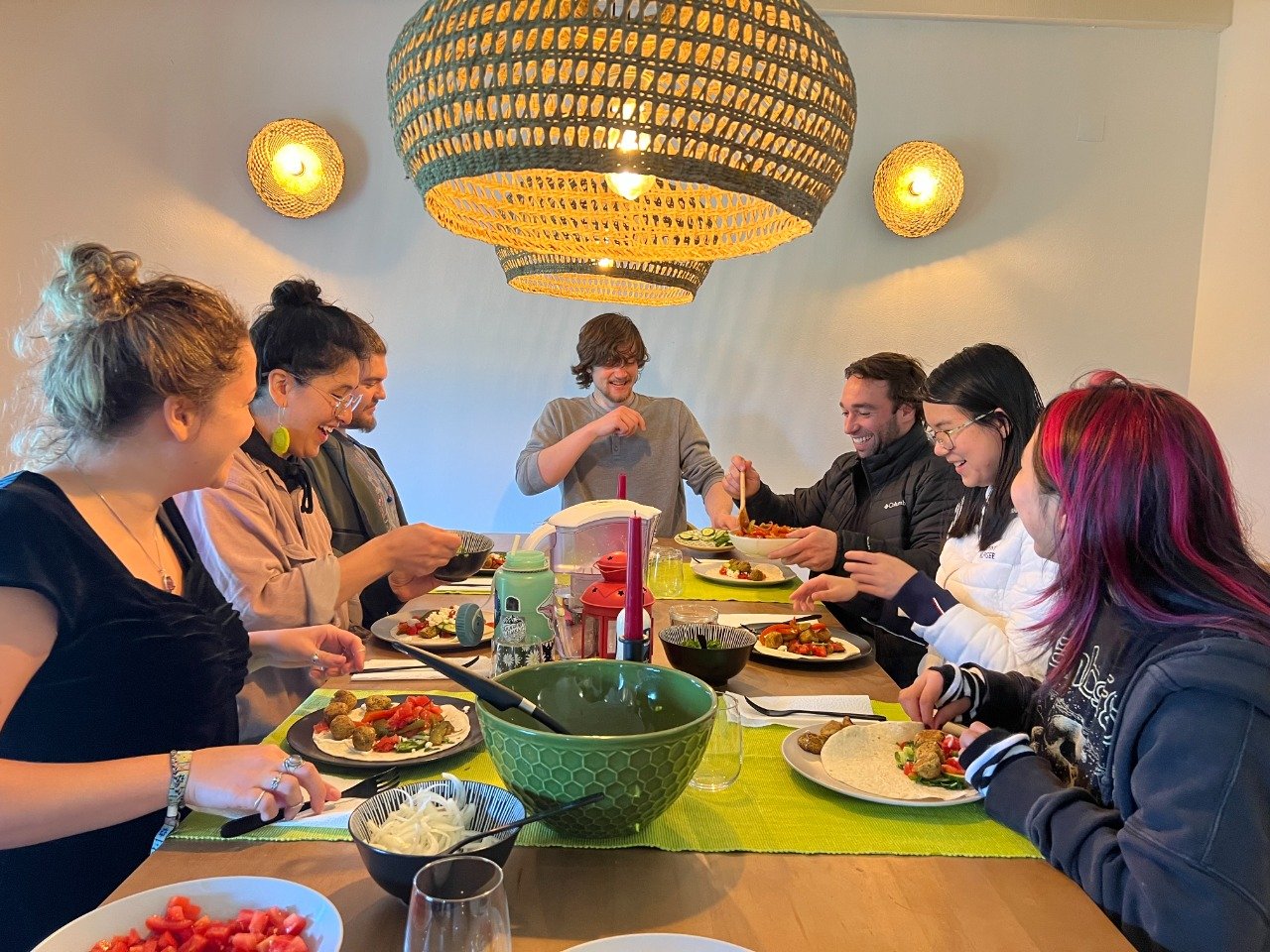 Young adults sharing a meal around a dinner table