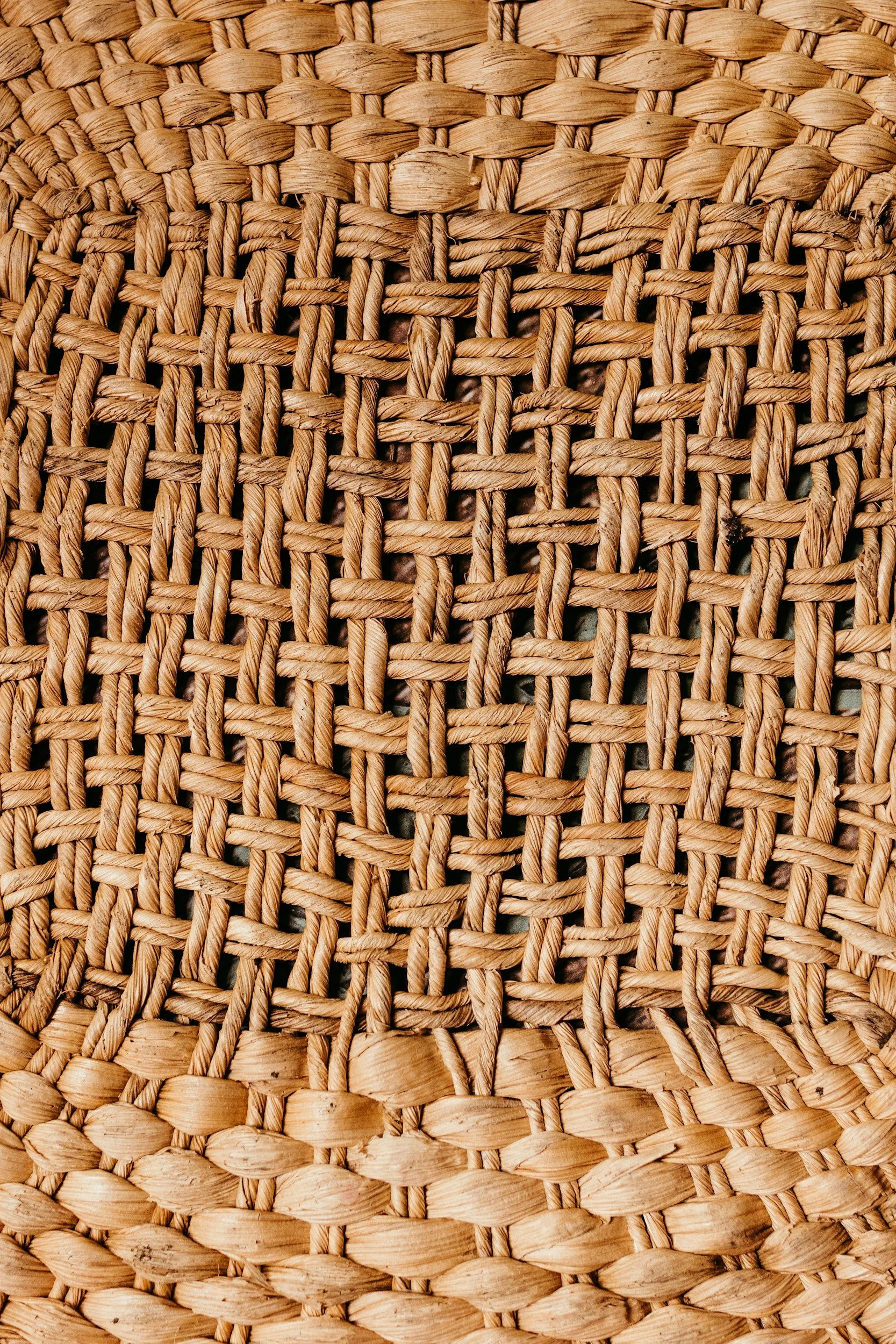 Close-up of woven natural fibers, possibly straw or rattan, forming a textured pattern.