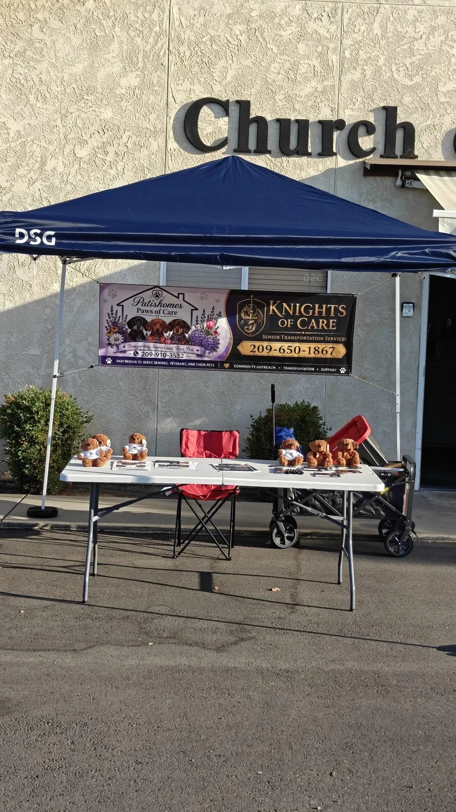 Knights of Care booth at Lodi Walk 4 Water: a navy canopy with the co-branded Knights of Care and Patishomes Paws of Care banner showing (209) 650-1867, and a table of teddy bears in white T-shirts