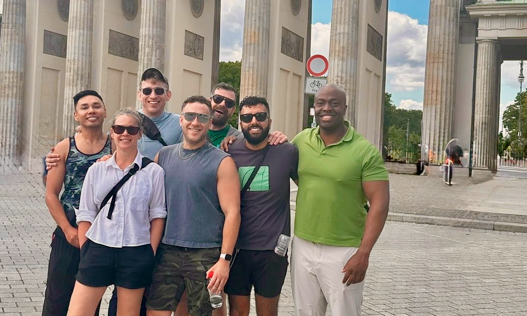 A group of friends posing together in front of Berlin’s Brandenburg Gate.