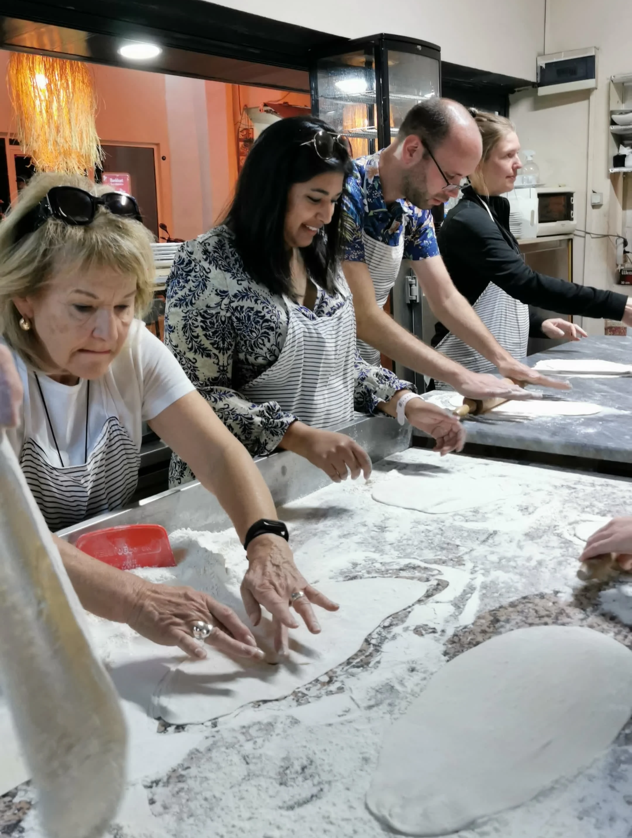 1. Travelers working together at a flour-covered table during a Turkish cooking experience.