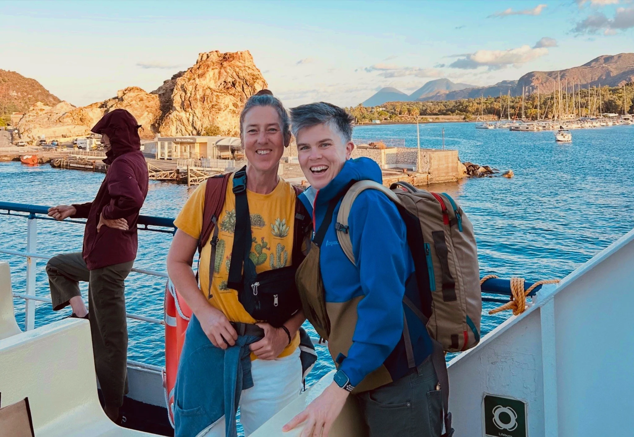 Briggs and Sonja smiling together on a ferry during their anniversary trip through Sicily.