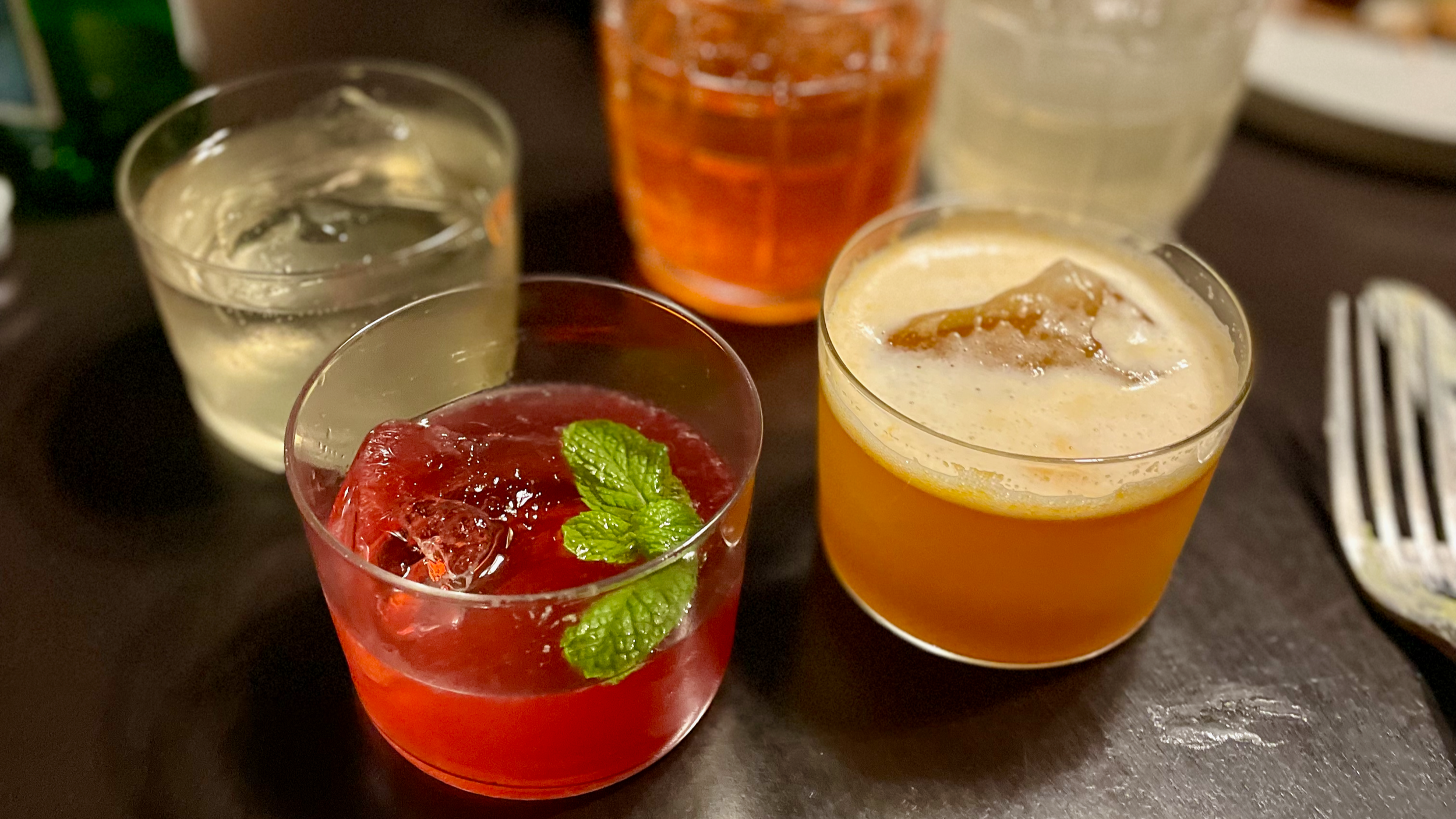 A table of colorful nonalcoholic cocktails and other drinks.
