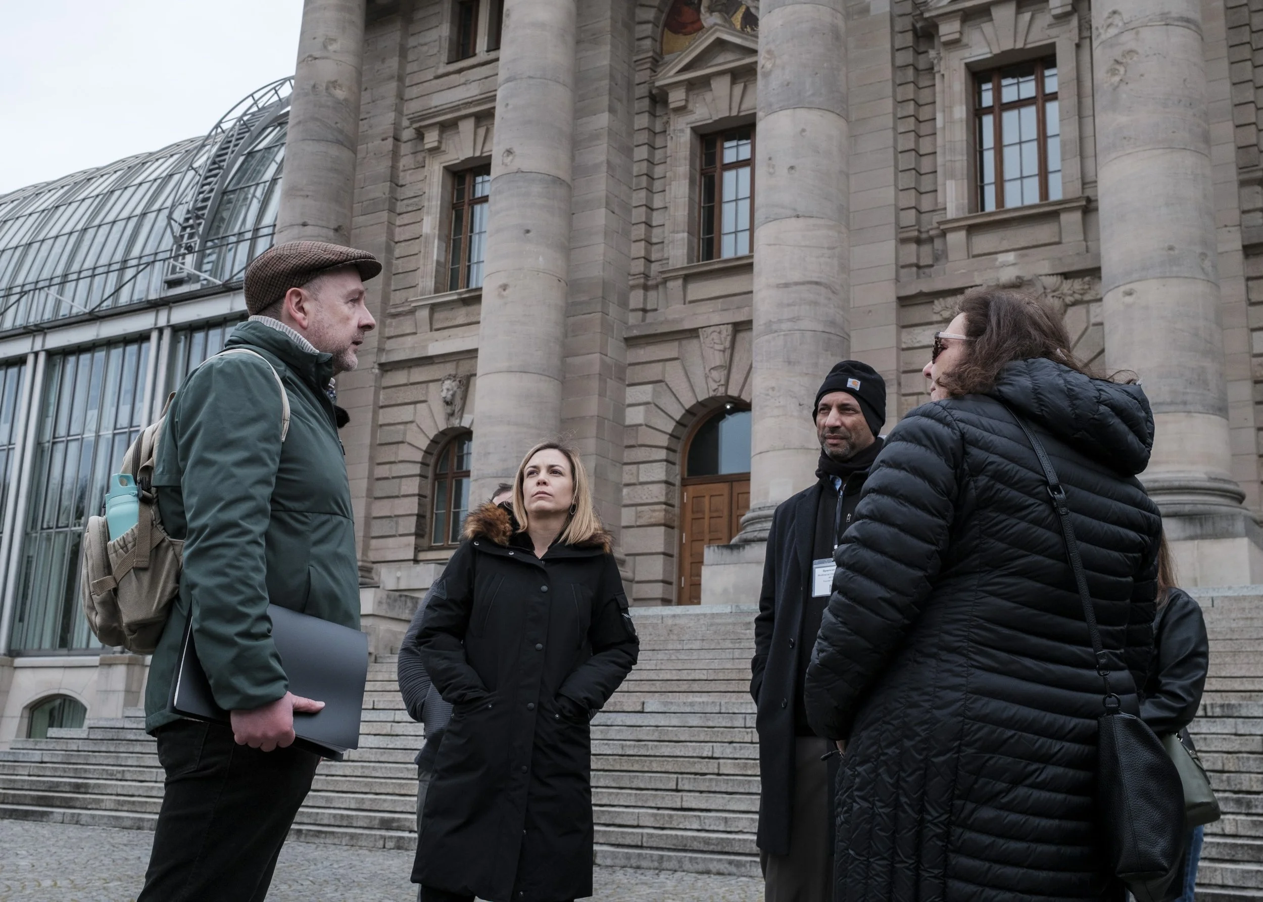 A guide speaking with a small group outside a government building in Berlin.