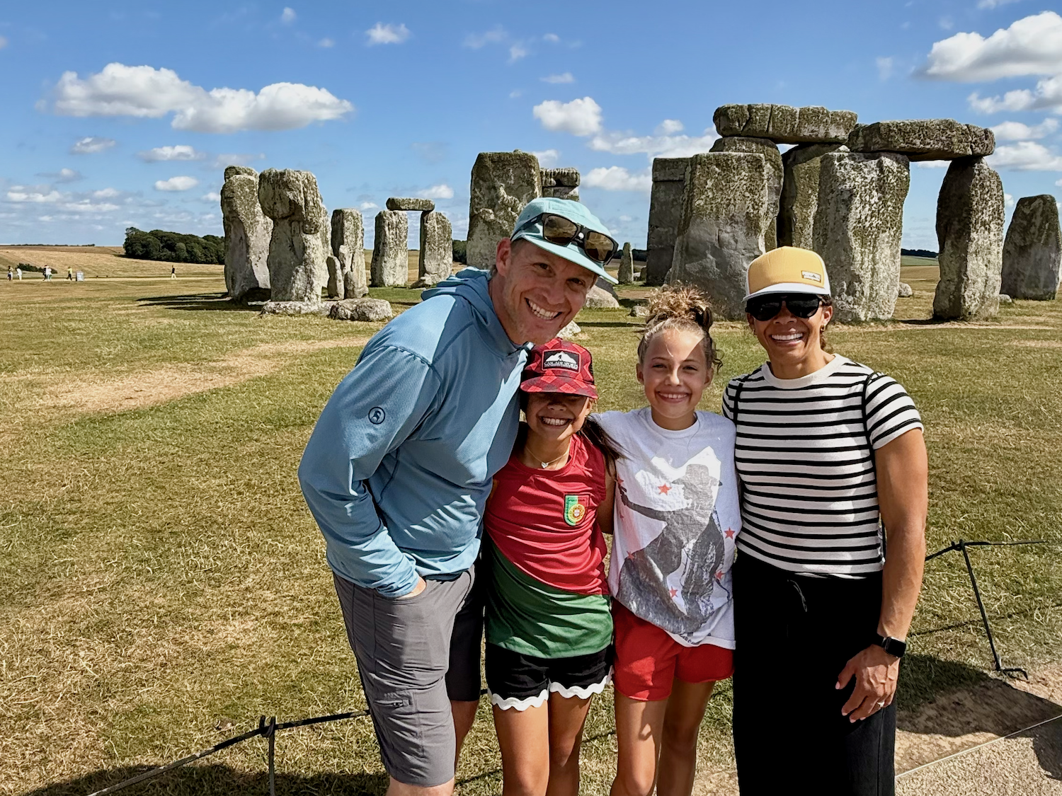 A family of four posing in front of Stonehenge