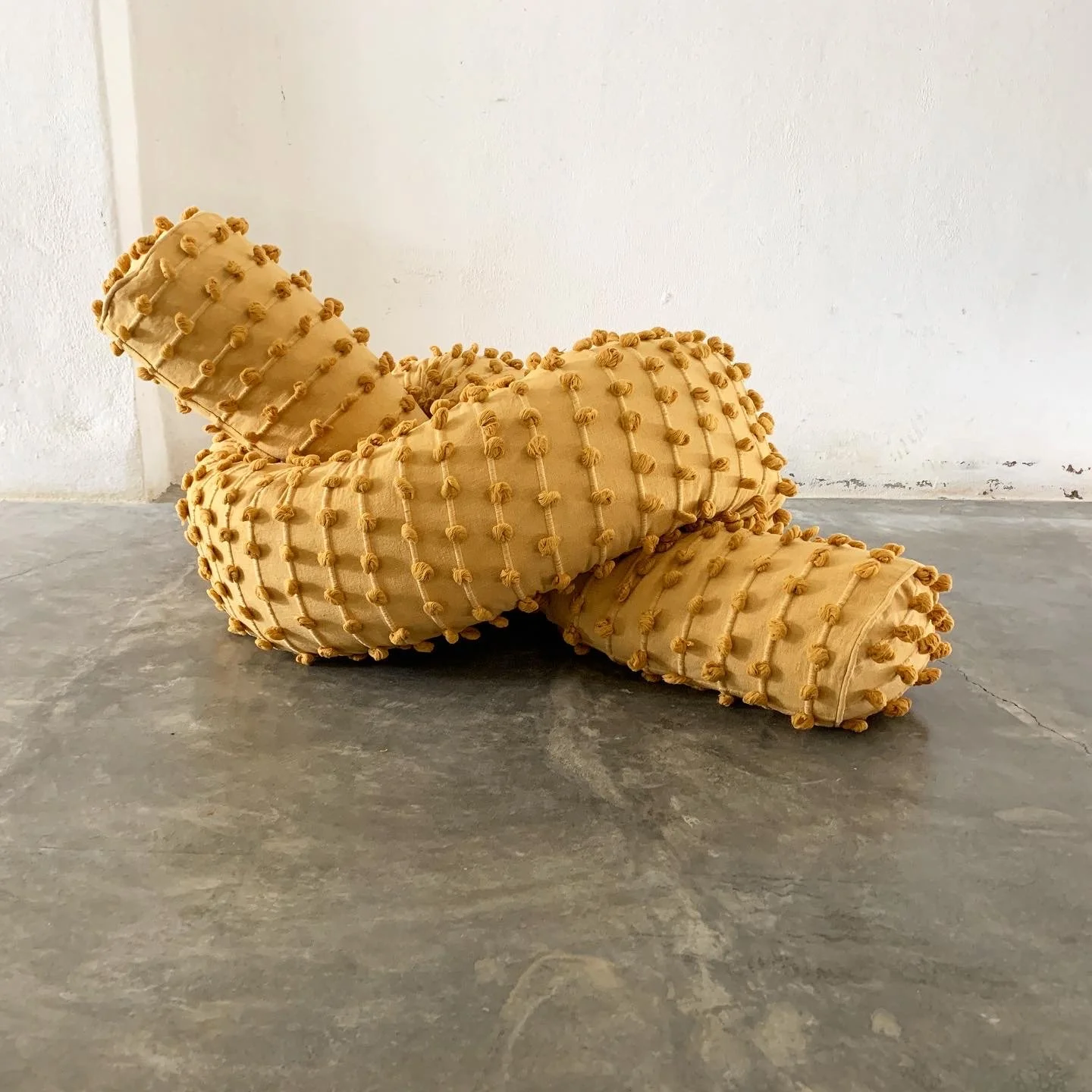 Mexchic Quetzalcoatl handwoven cotton pillow serpent snake seat chair oaxaca  mexchic wool contemporary design aztec pop culture soft sculpture texture yellow ochre mustard puffs 