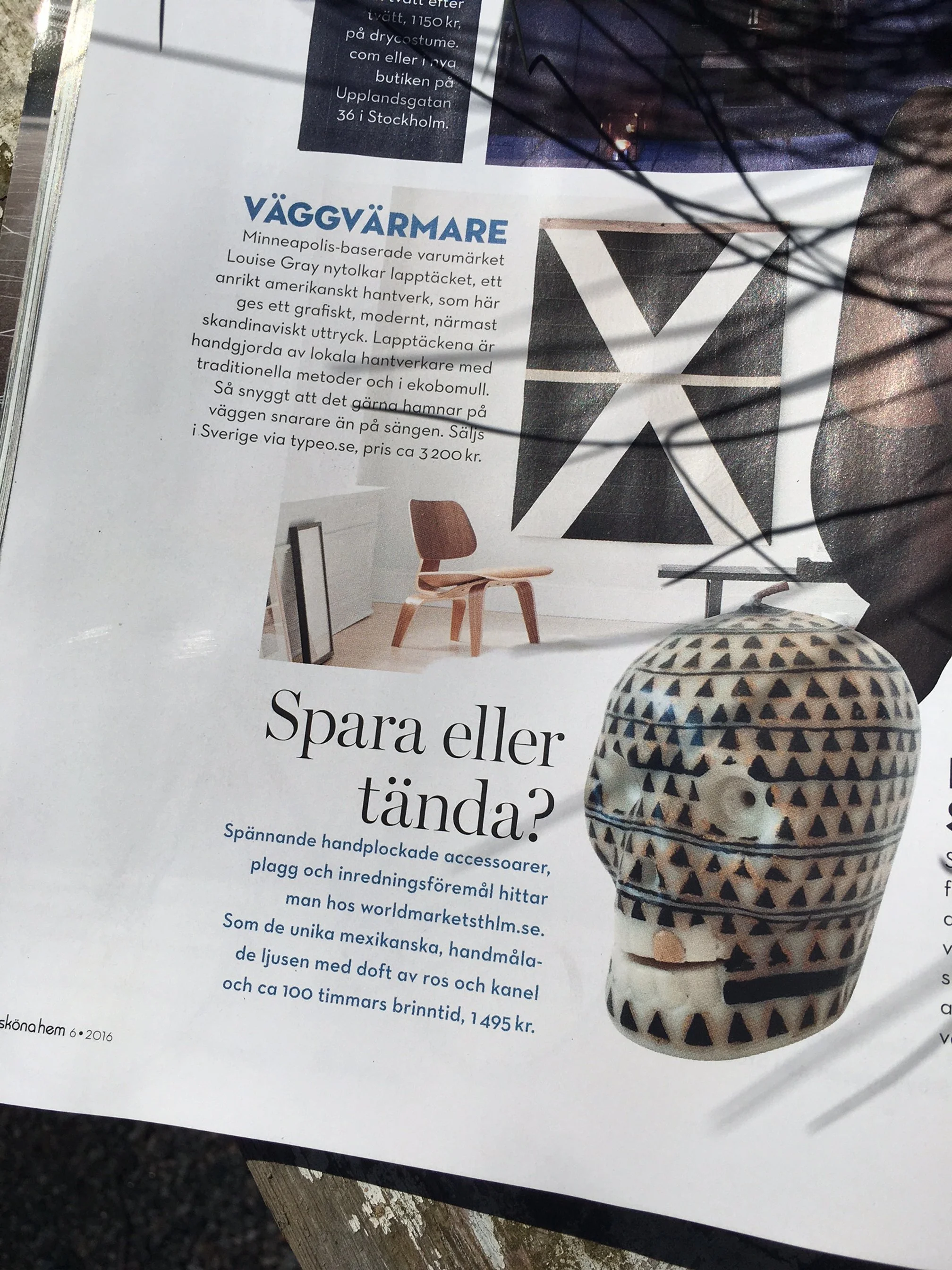 A magazine page with text in Swedish, featuring a black-and-white wall art piece, and a decorative ceramic object with a geometric pattern.