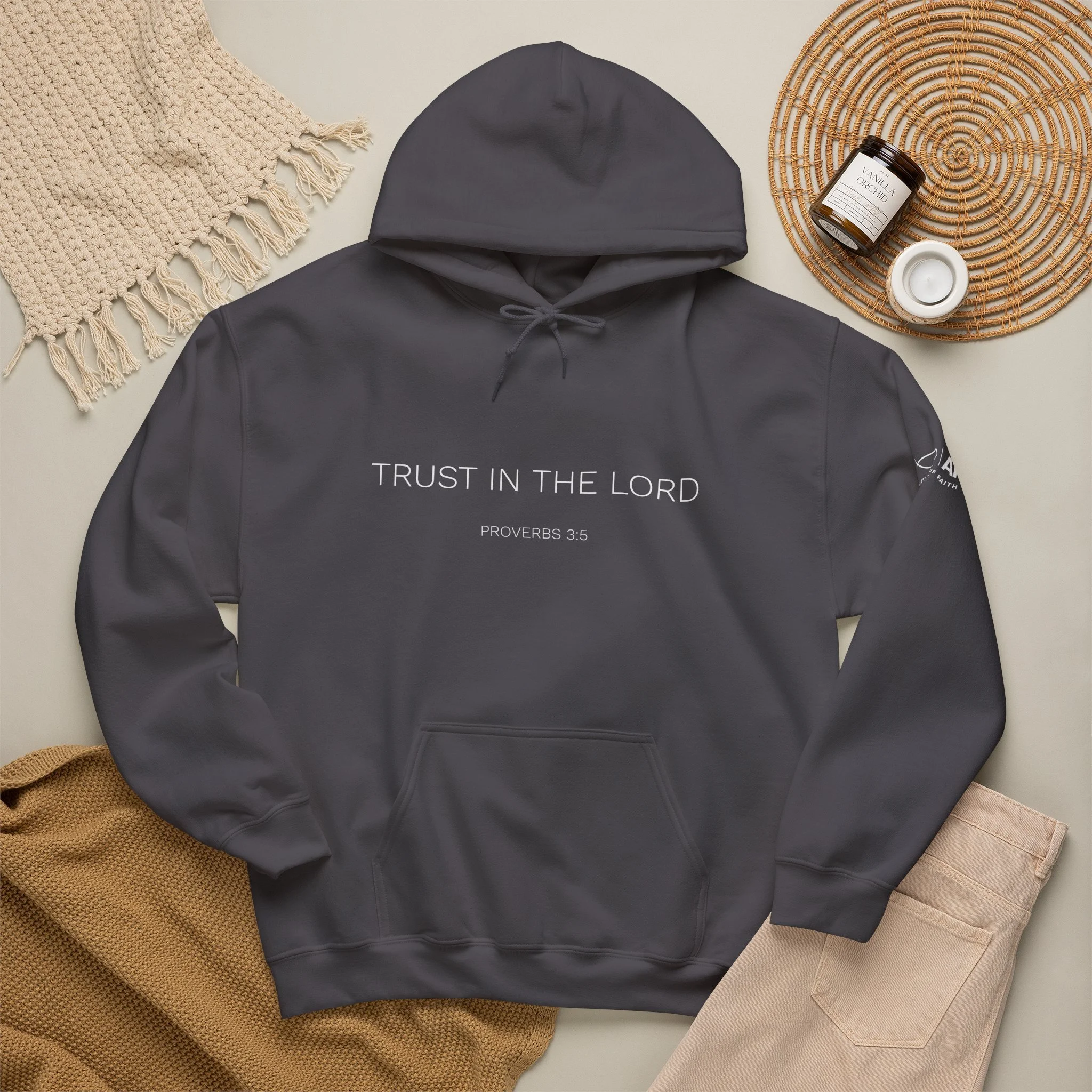 Lifestyle flat lay featuring Articles of Faith Scripture-inspired apparel with TRUST IN THE LORD on the front.