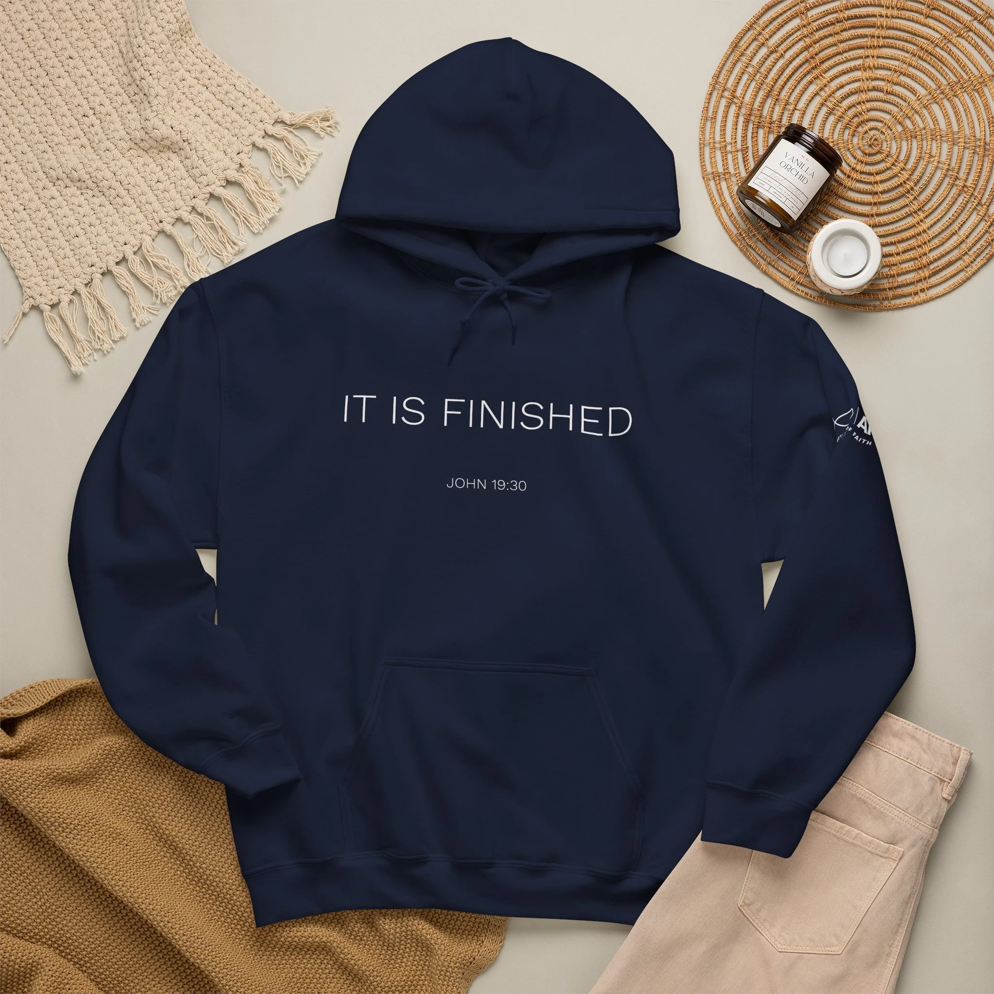 Lifestyle flat lay featuring Articles of Faith Scripture-inspired apparel with IT IS FINISHED on the front