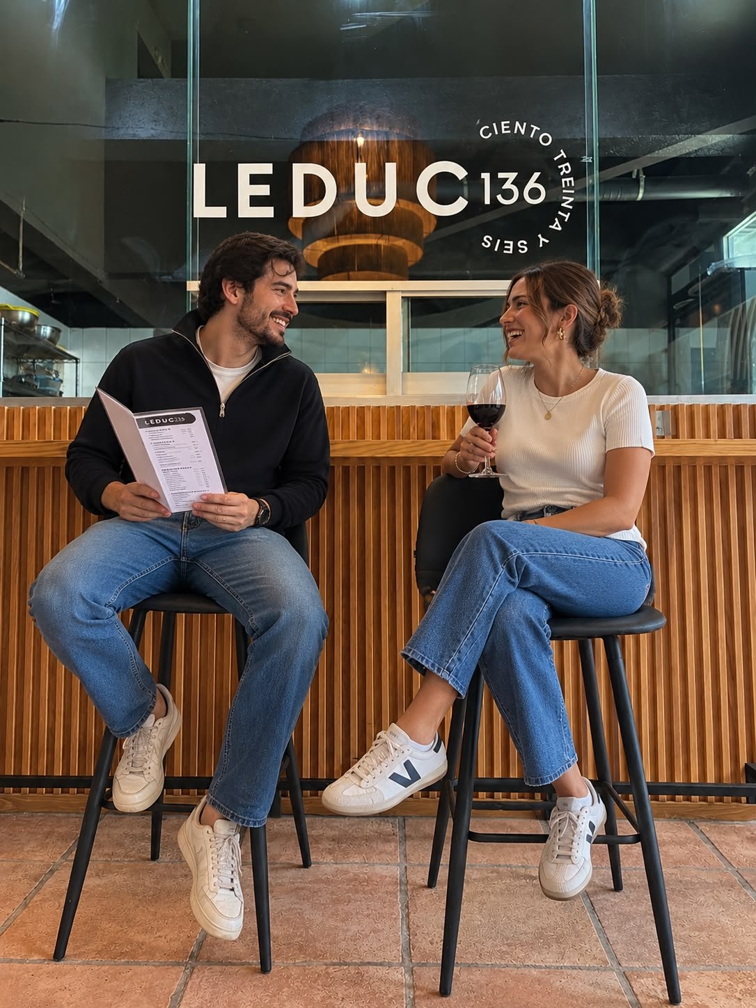 Pareja sonriente esperando para ordenar su desayuno en el ambiente acogedor del café Leduc 136
