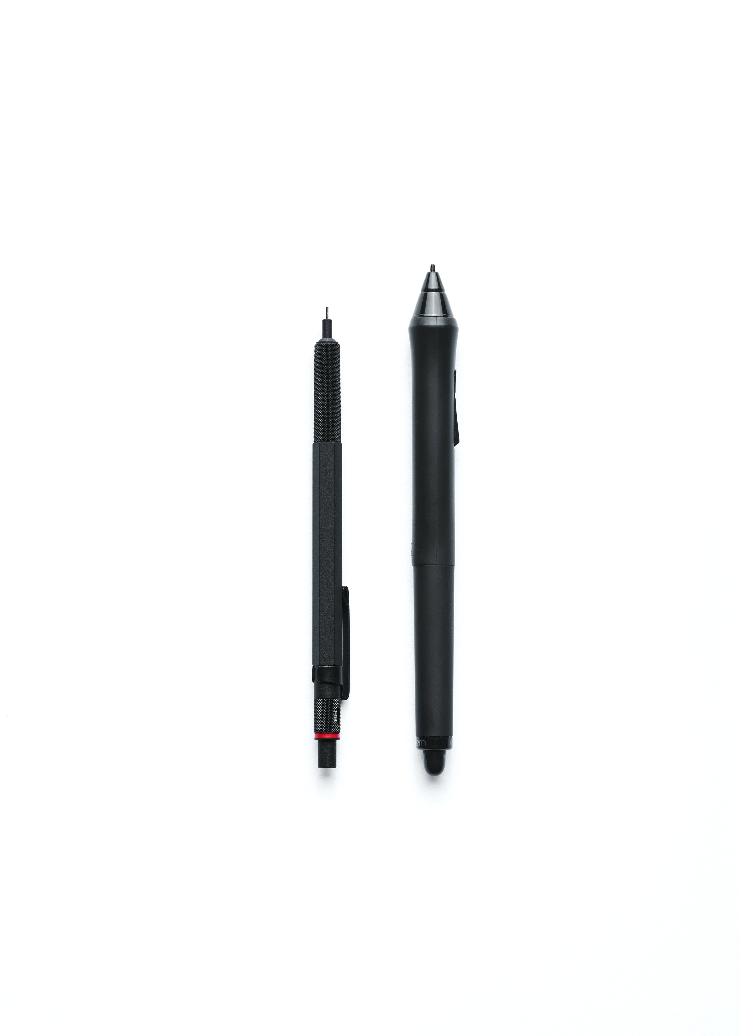 Two black drafting pens, one with a textured grip and the other with a smooth surface and a clip, placed vertically on a white background.