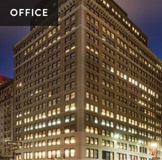 A tall office building at night with numerous lit windows.